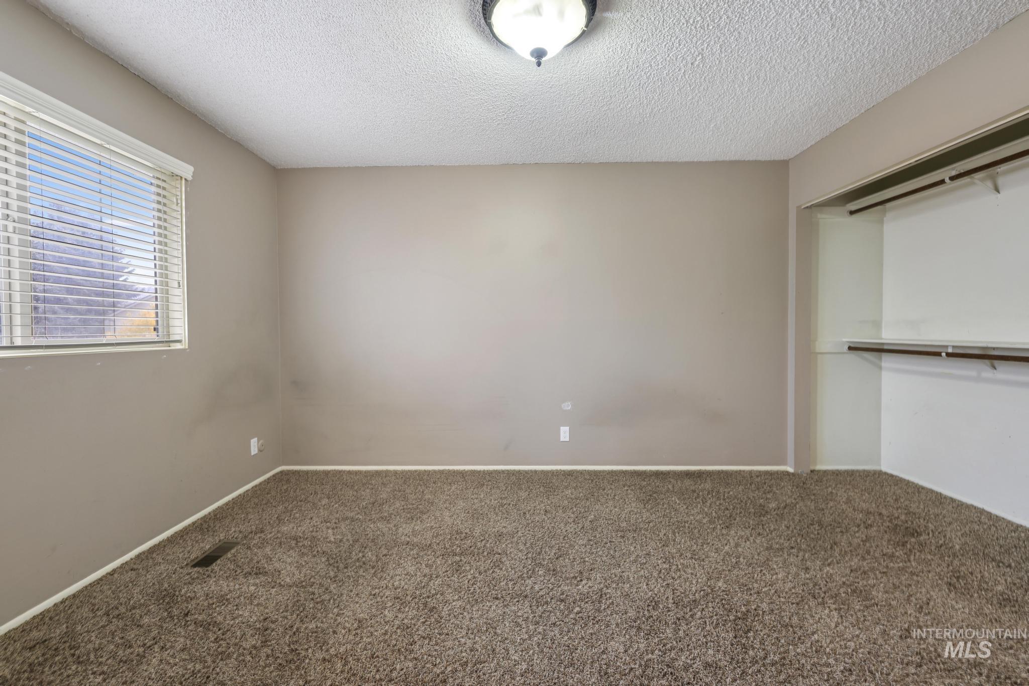 Unfurnished bedroom featuring carpet flooring, a closet, and a textured ceiling