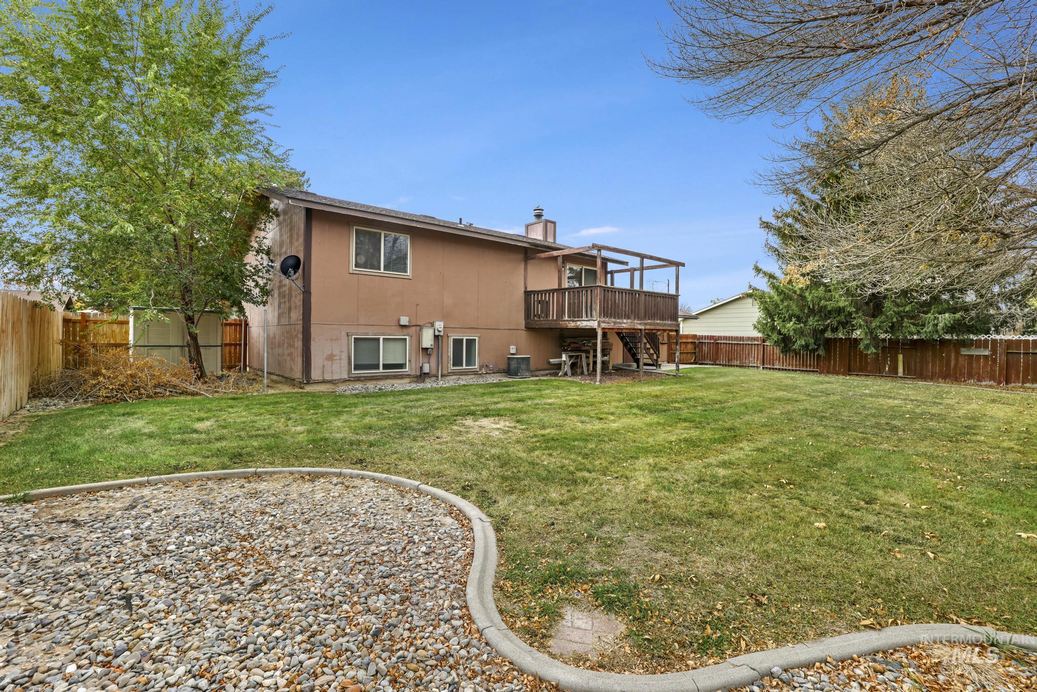 Back of property with stairs, a chimney, a fenced backyard, and a wooden deck