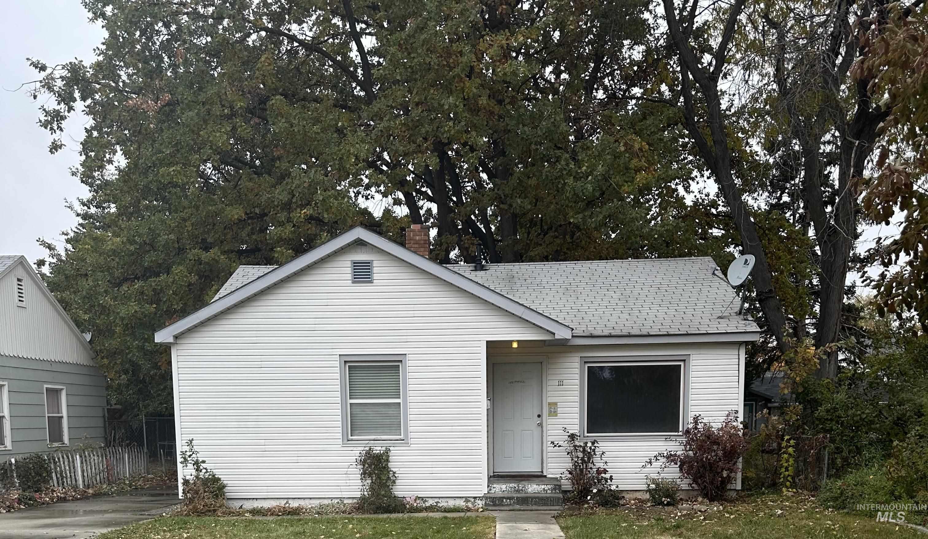 Bungalow featuring a shingled roof and a chimney