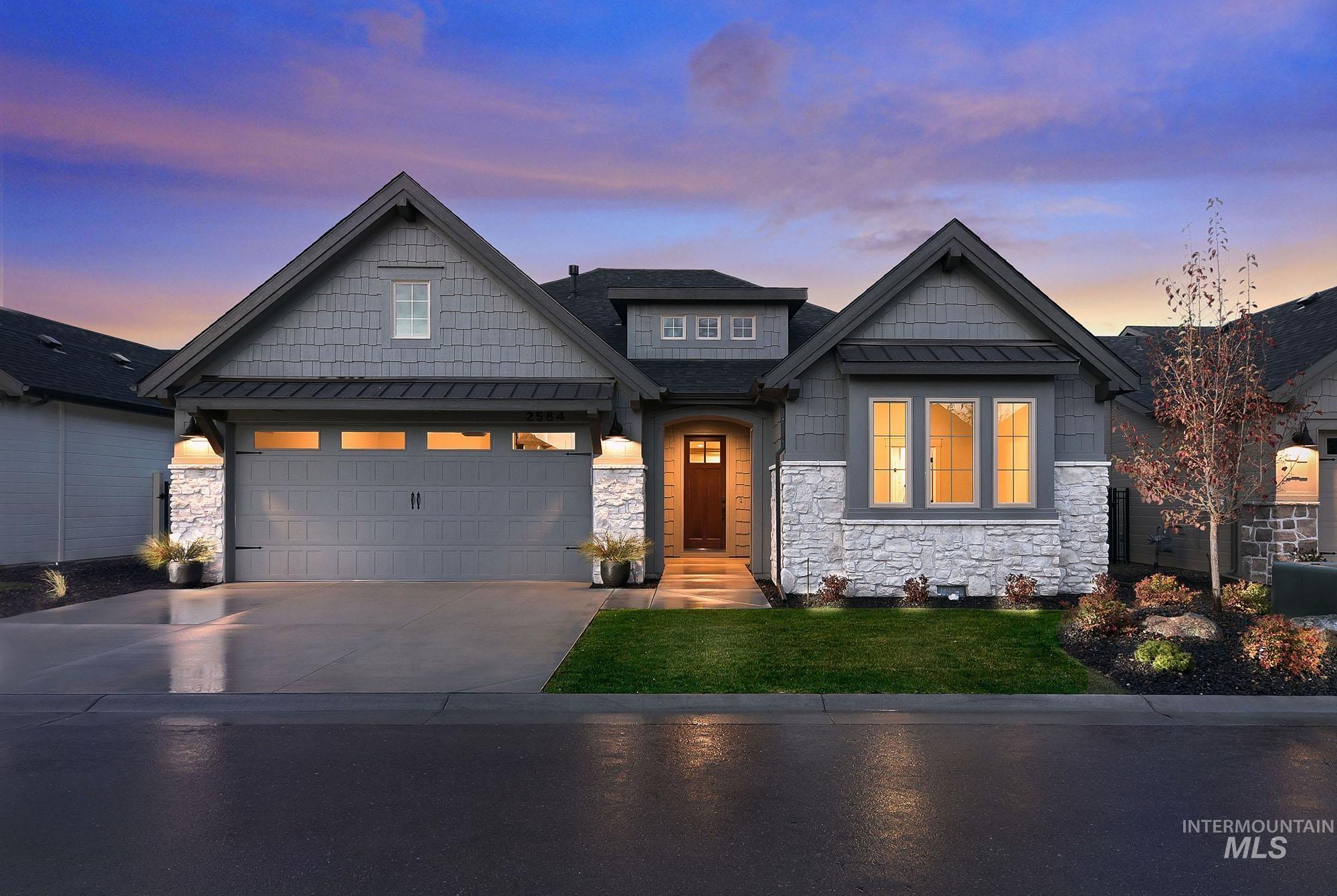 Craftsman house featuring stone siding, concrete driveway, and a yard