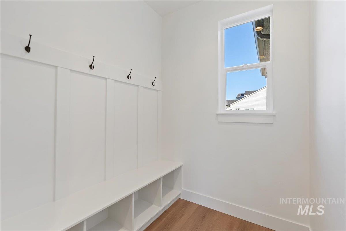 Mudroom featuring light wood-style flooring and baseboards