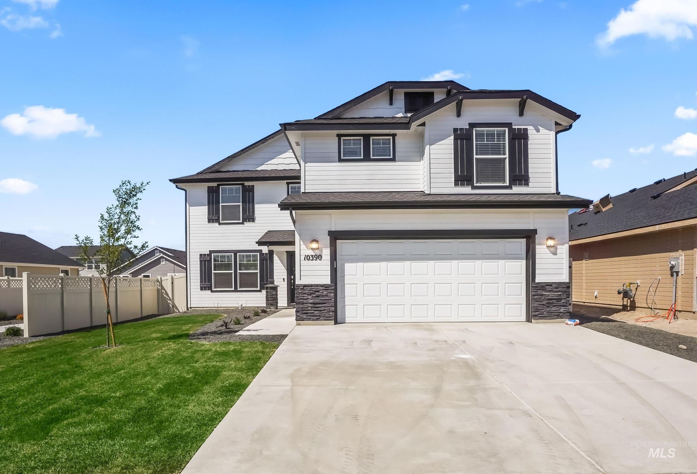 Traditional-style house featuring driveway, a garage, and stone siding
