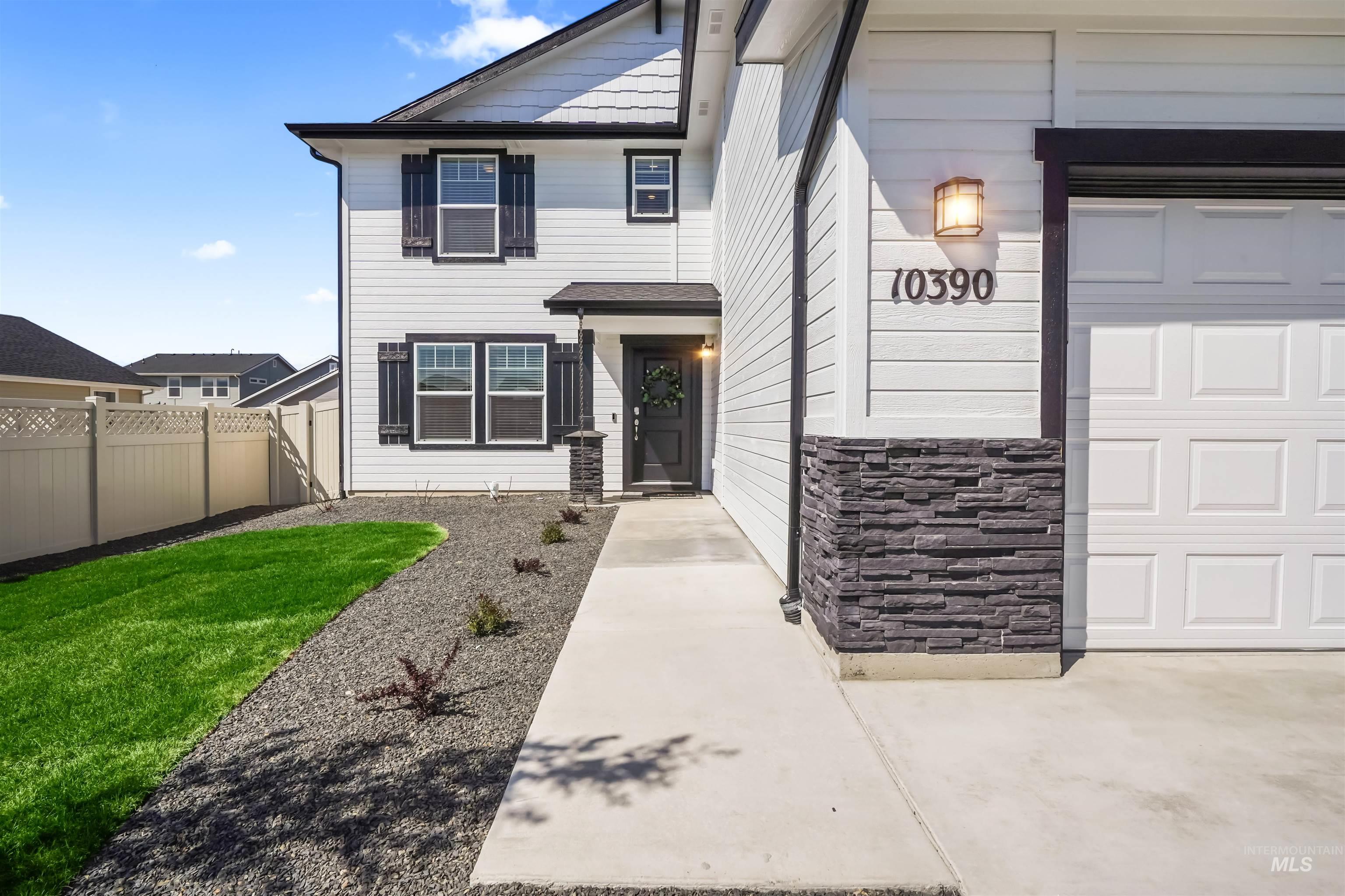Entrance to property featuring stone siding and a garage