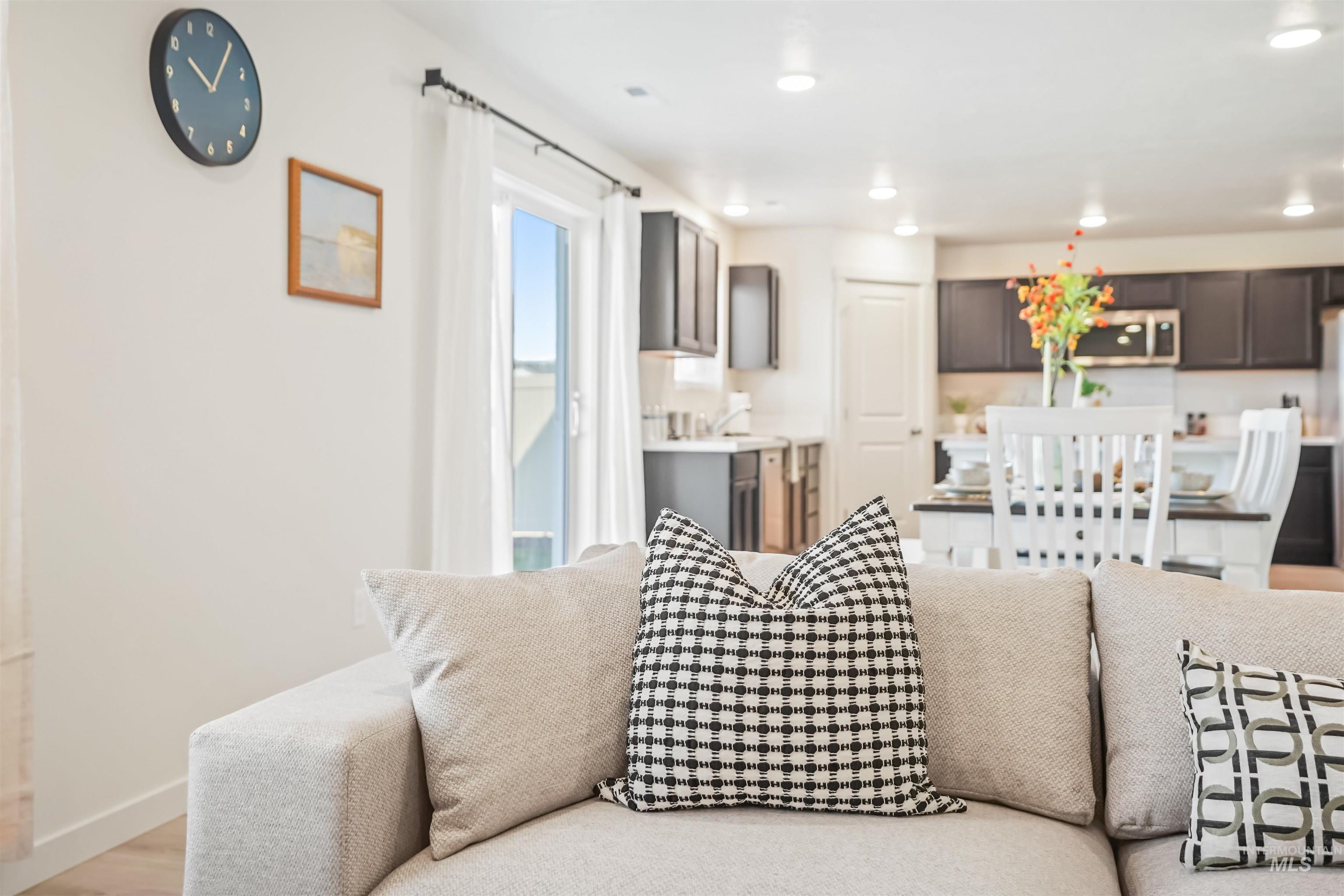 Living area with light wood finished floors and recessed lighting