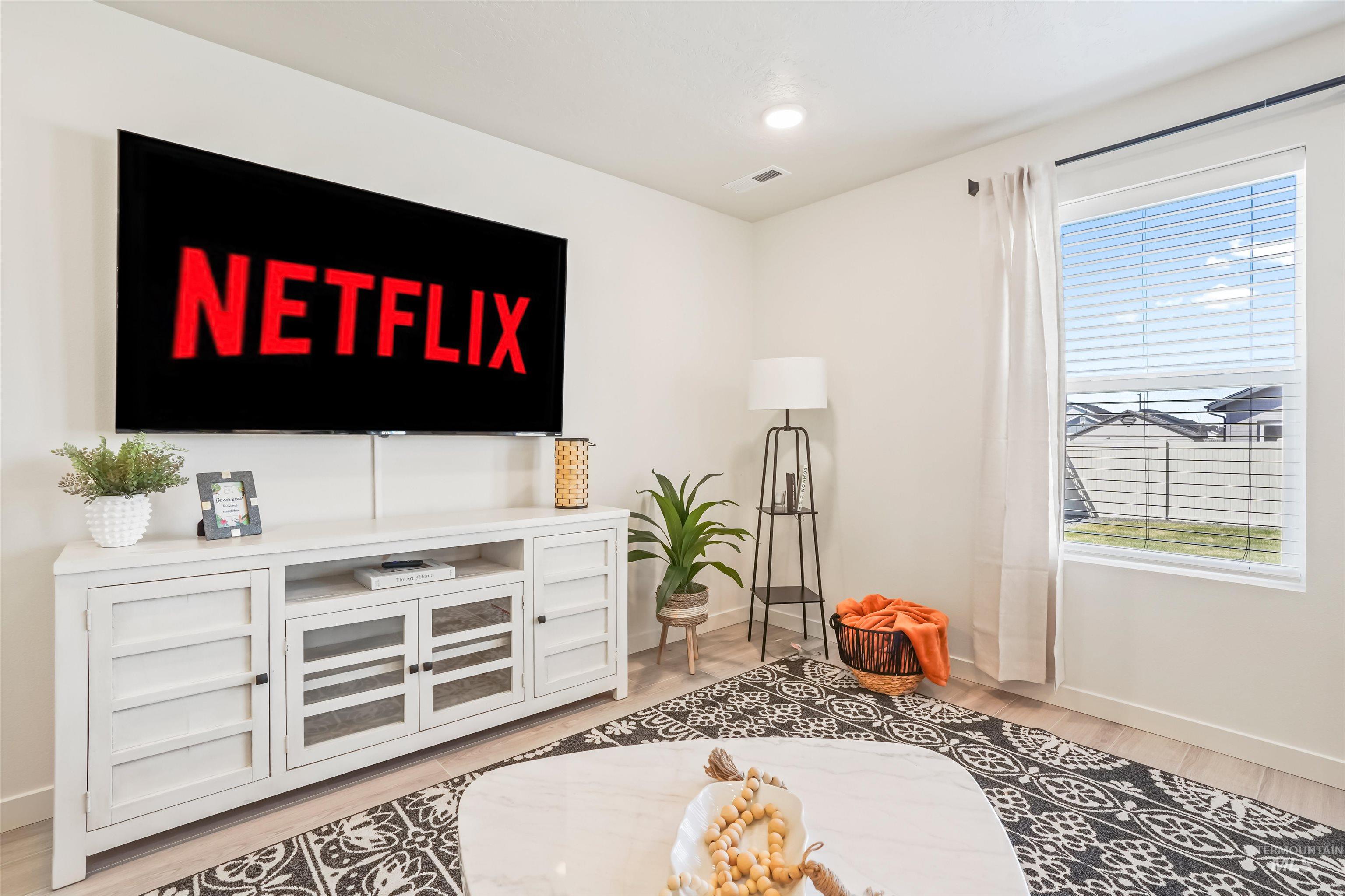 Living area with light wood-style flooring and recessed lighting
