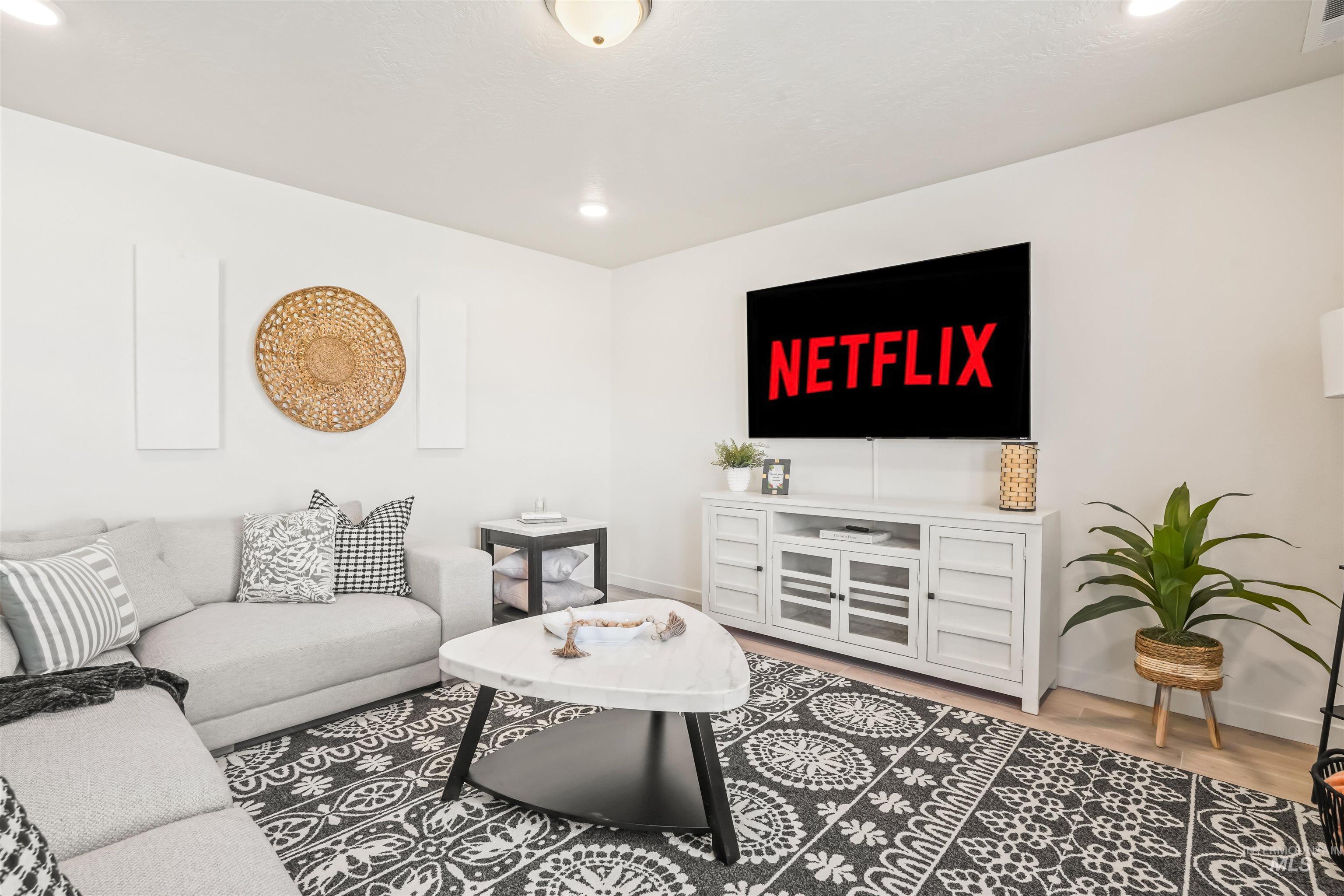 Living area with light wood-style flooring and recessed lighting