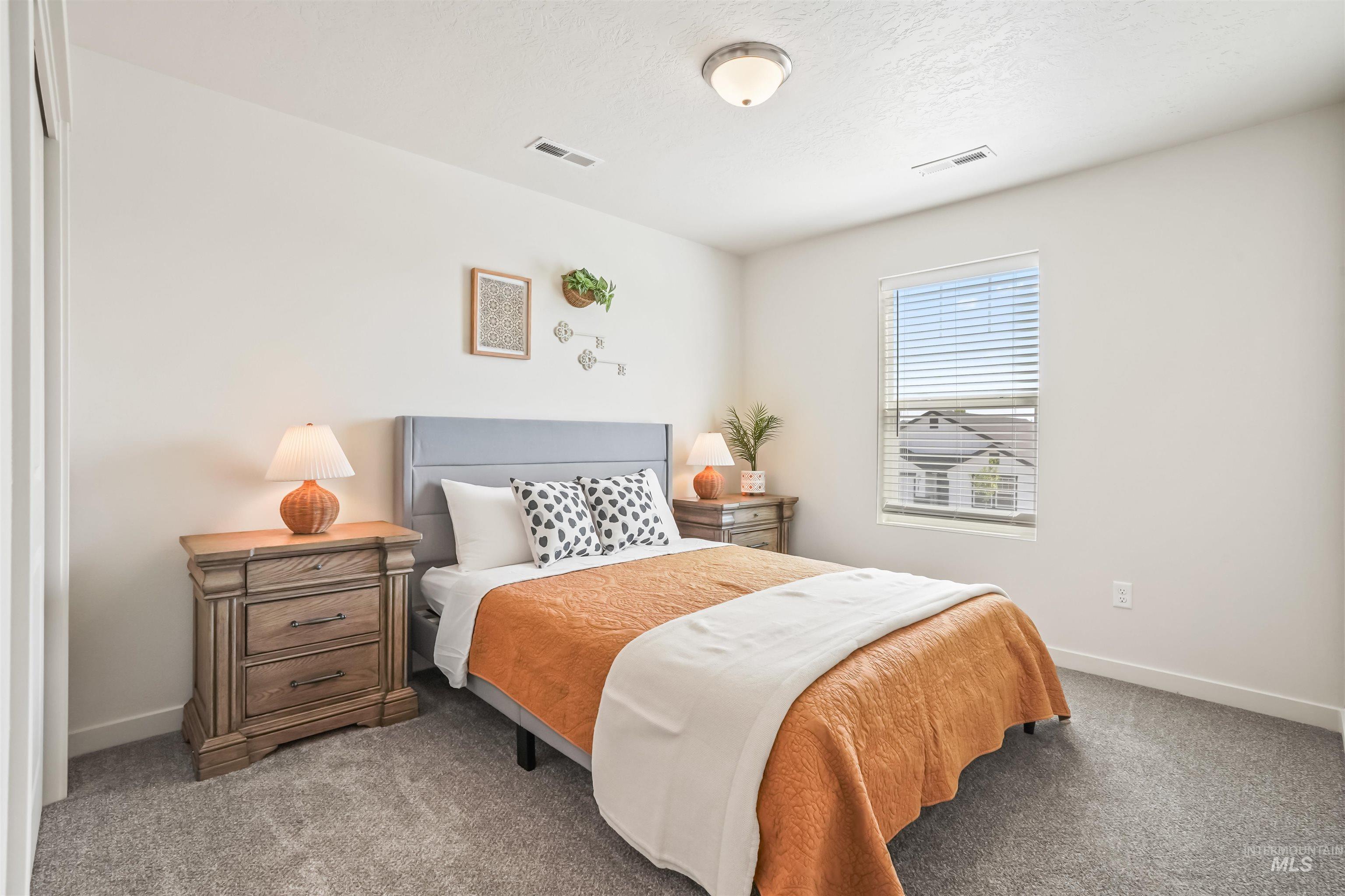 Carpeted bedroom with baseboards and a textured ceiling