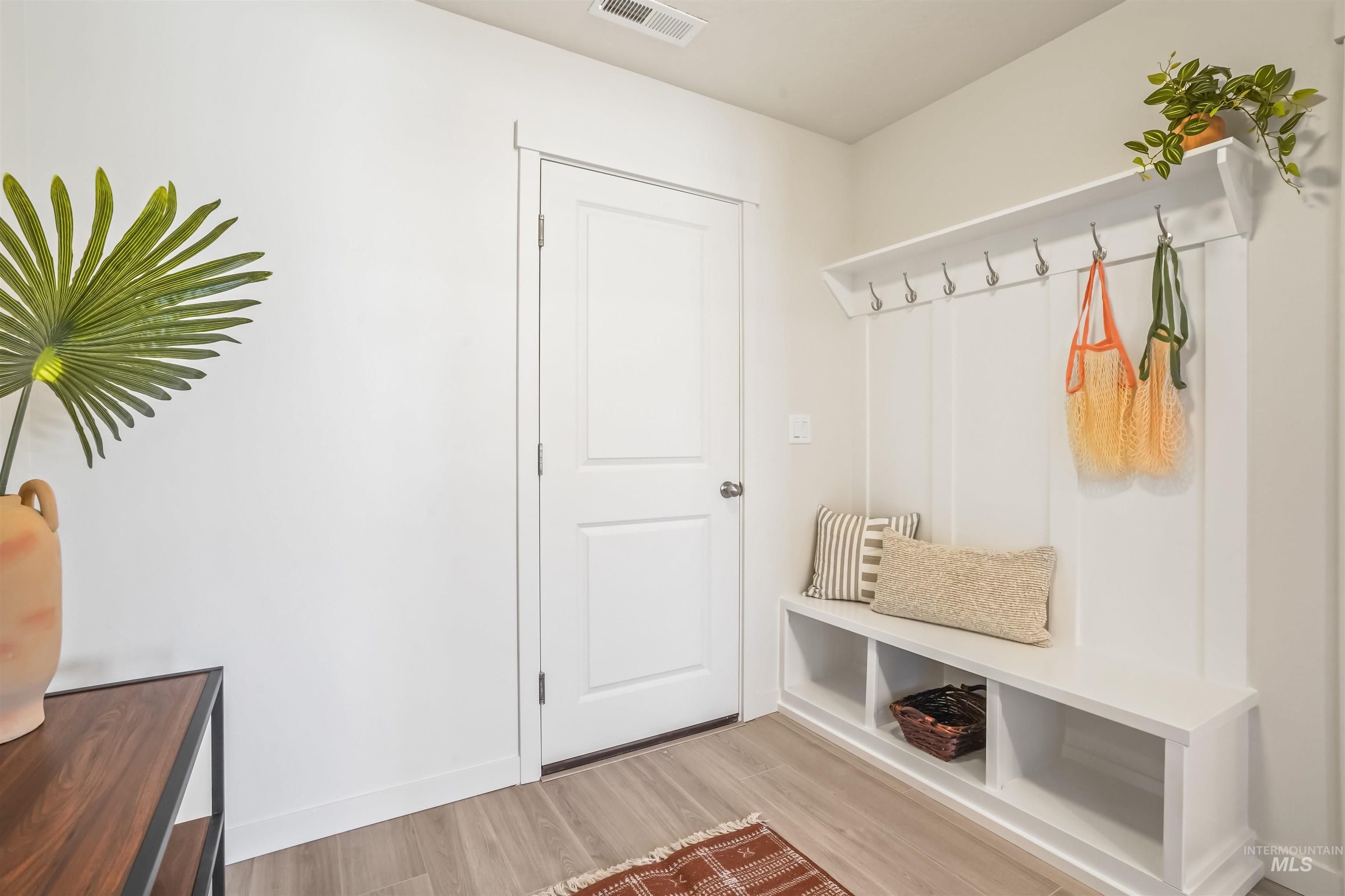 Mudroom with light wood-style flooring and baseboards