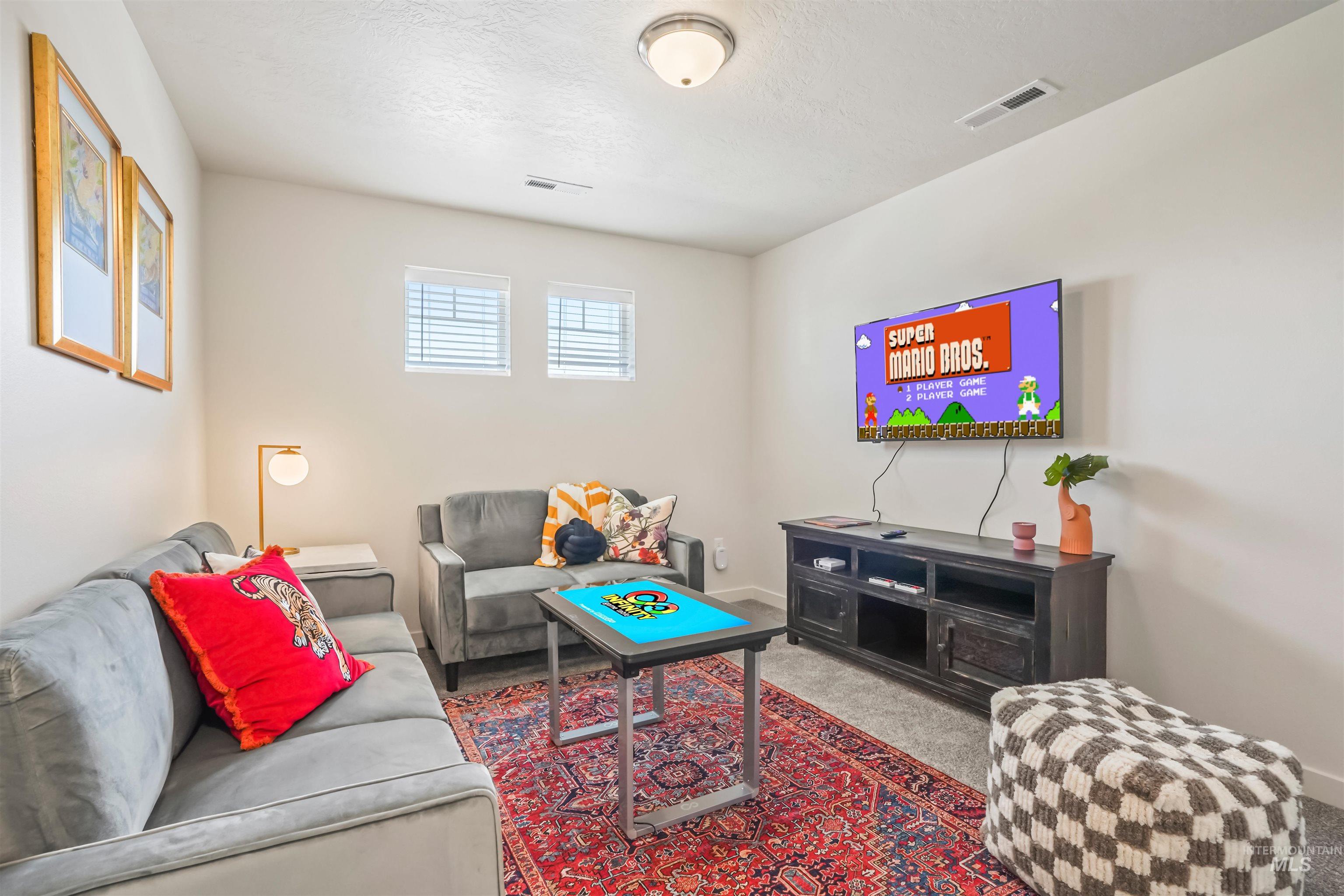 Carpeted living room featuring a textured ceiling and baseboards