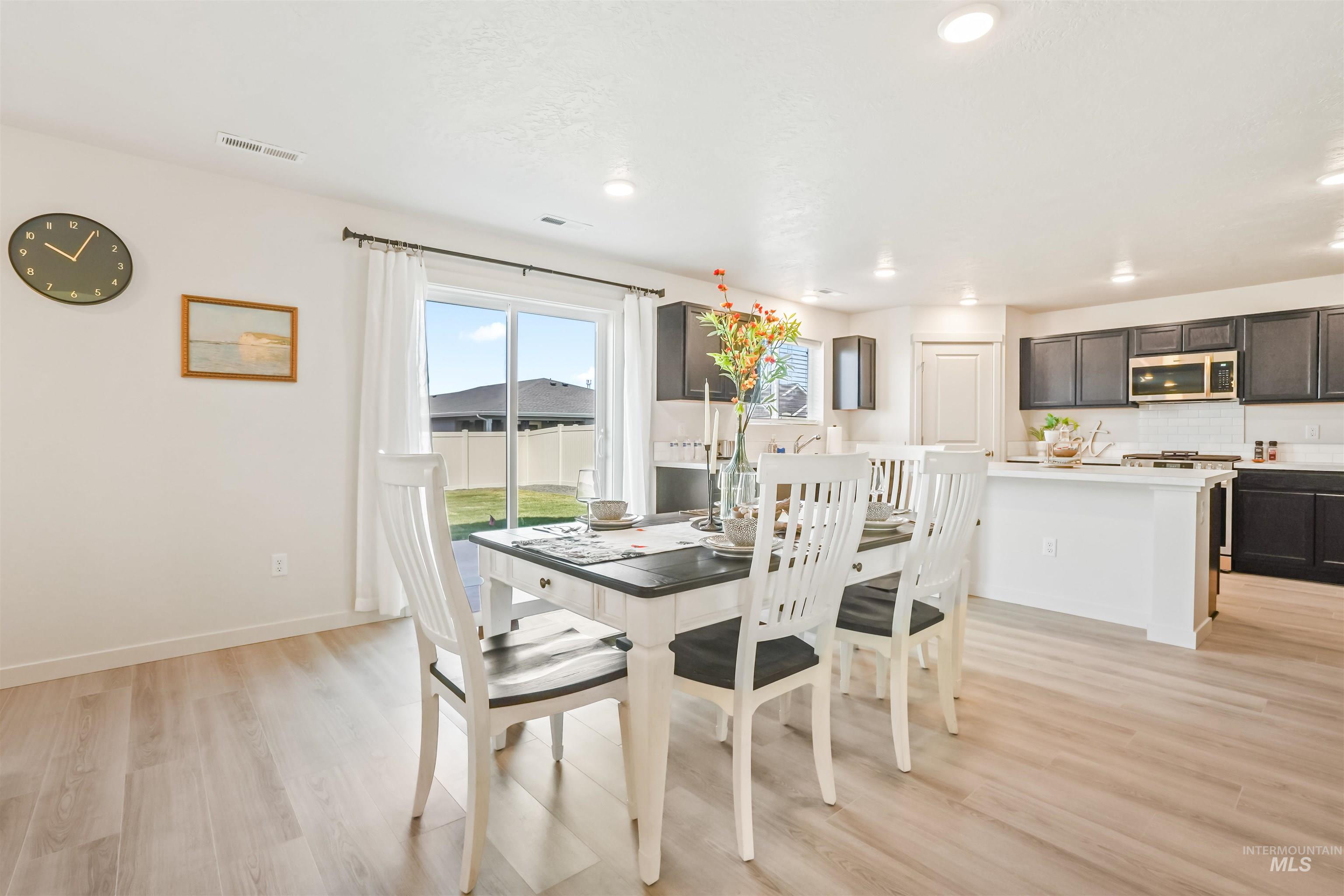Dining room with light wood-type flooring and recessed lighting
