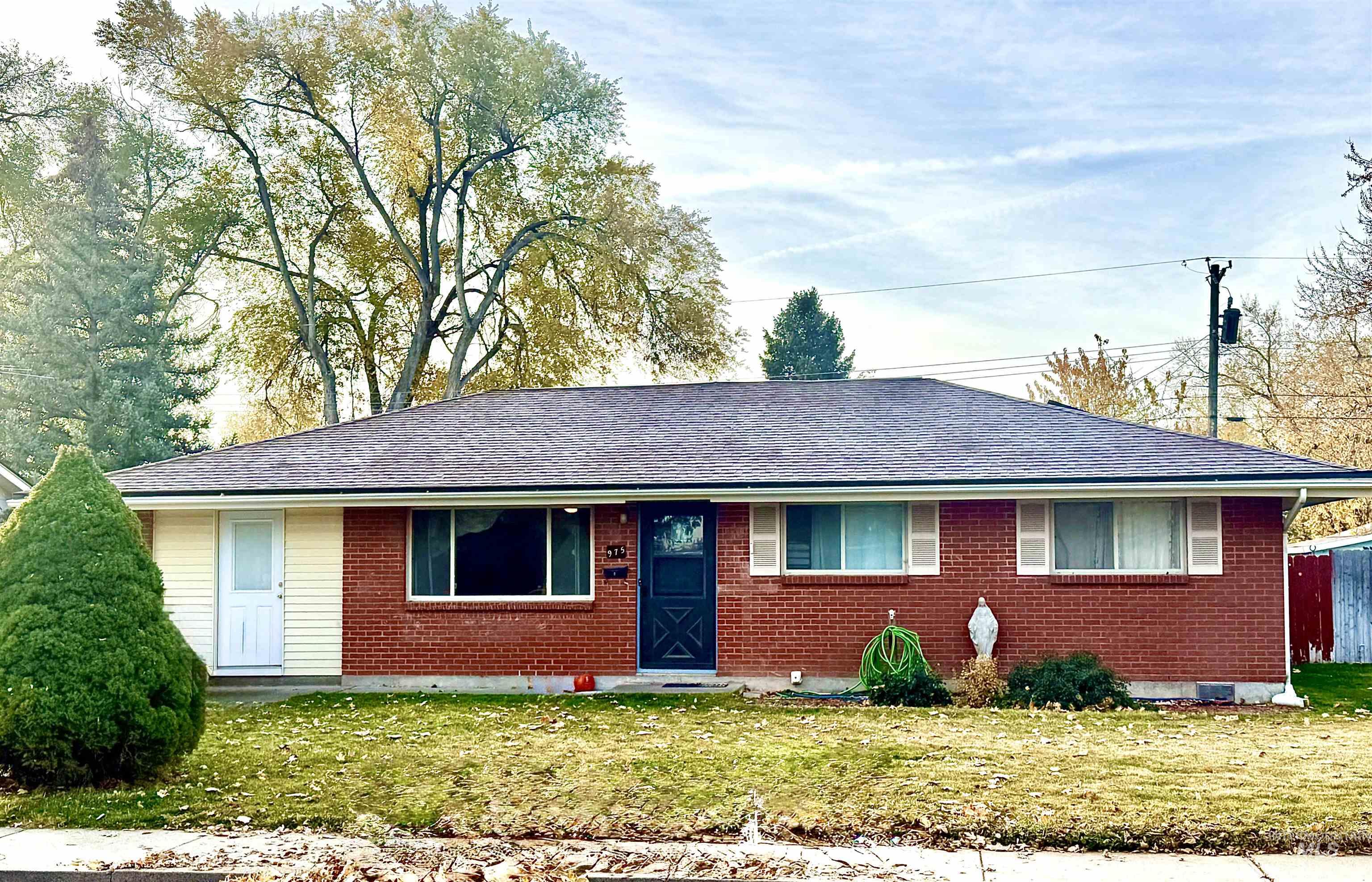 Ranch-style house with a front yard, brick siding, and a shingled roof