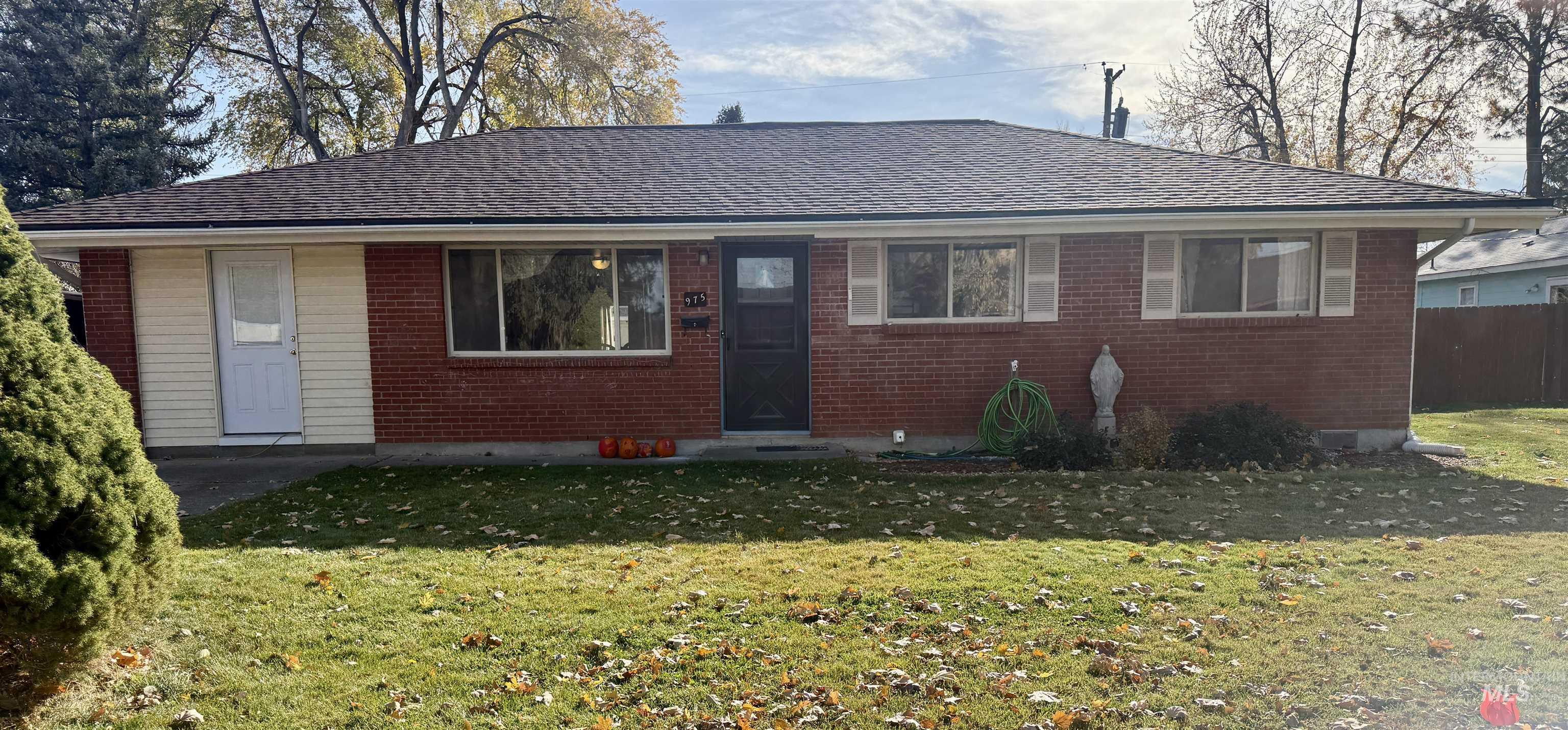 View of front of house featuring brick siding, a front lawn, and roof with shingles