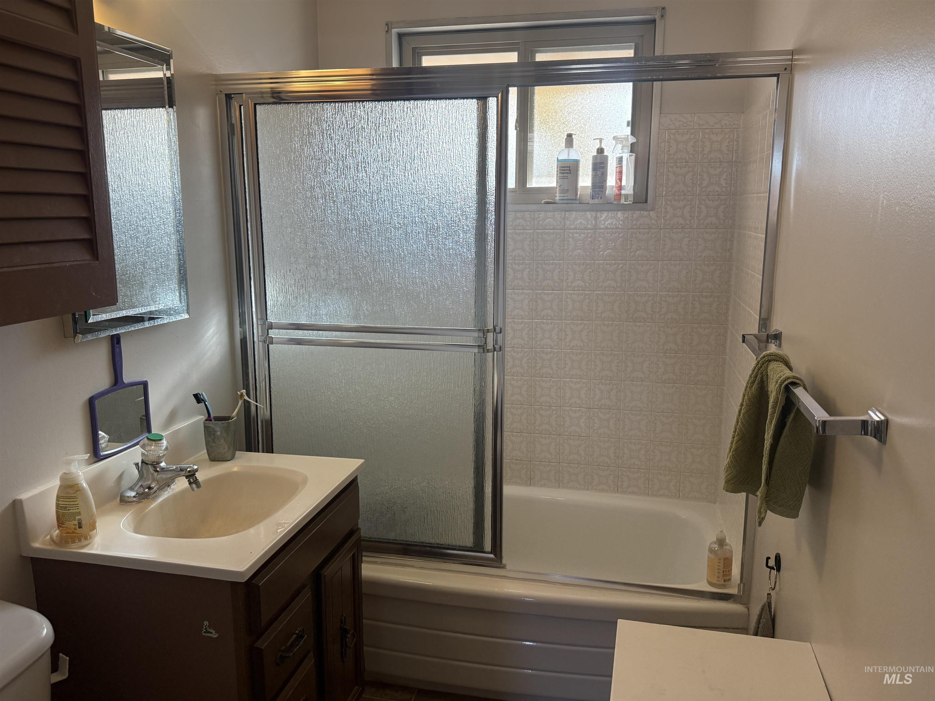 Bathroom with vanity and shower / bath combination with glass door