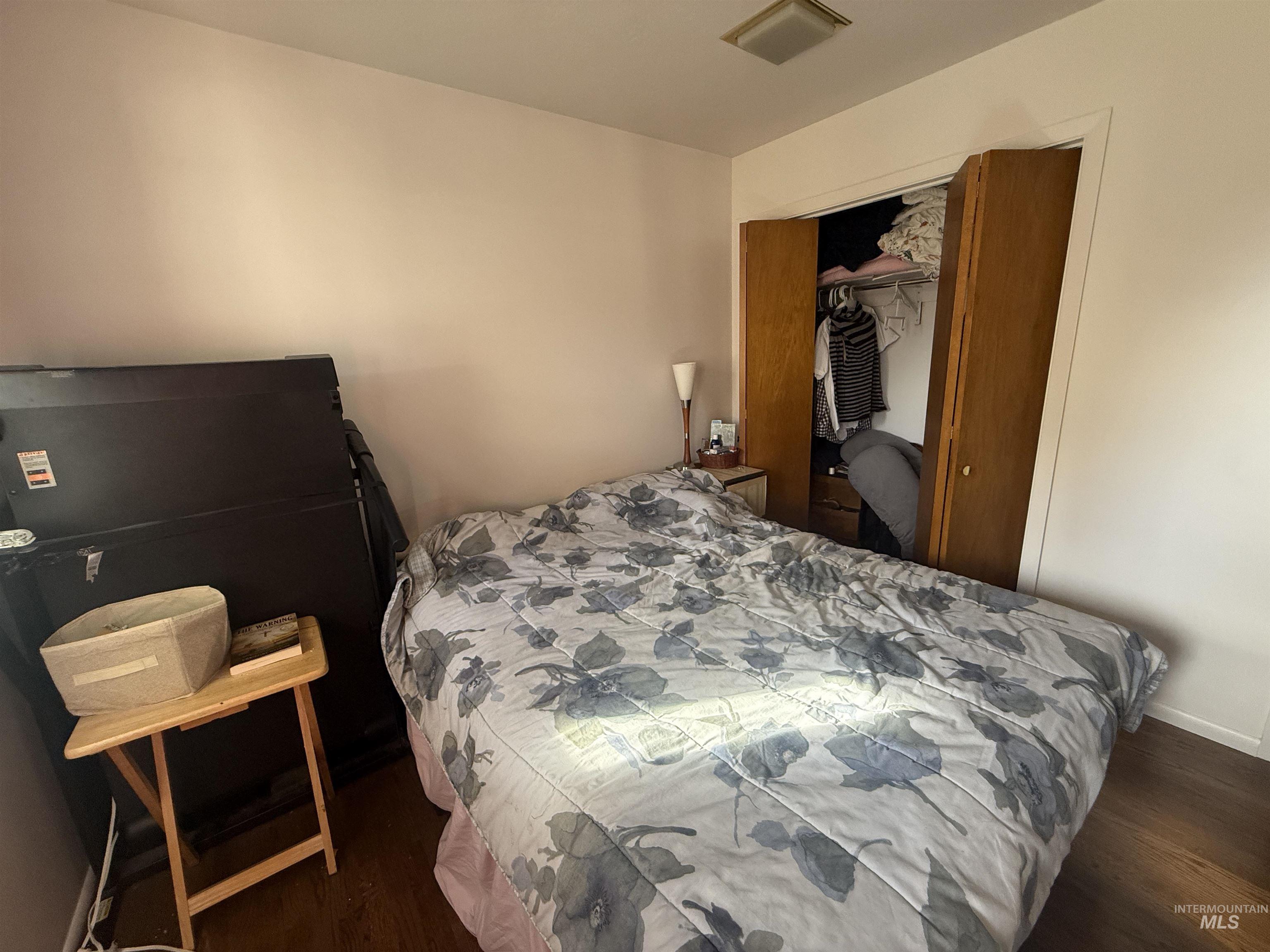 Bedroom featuring a closet and dark wood-type flooring