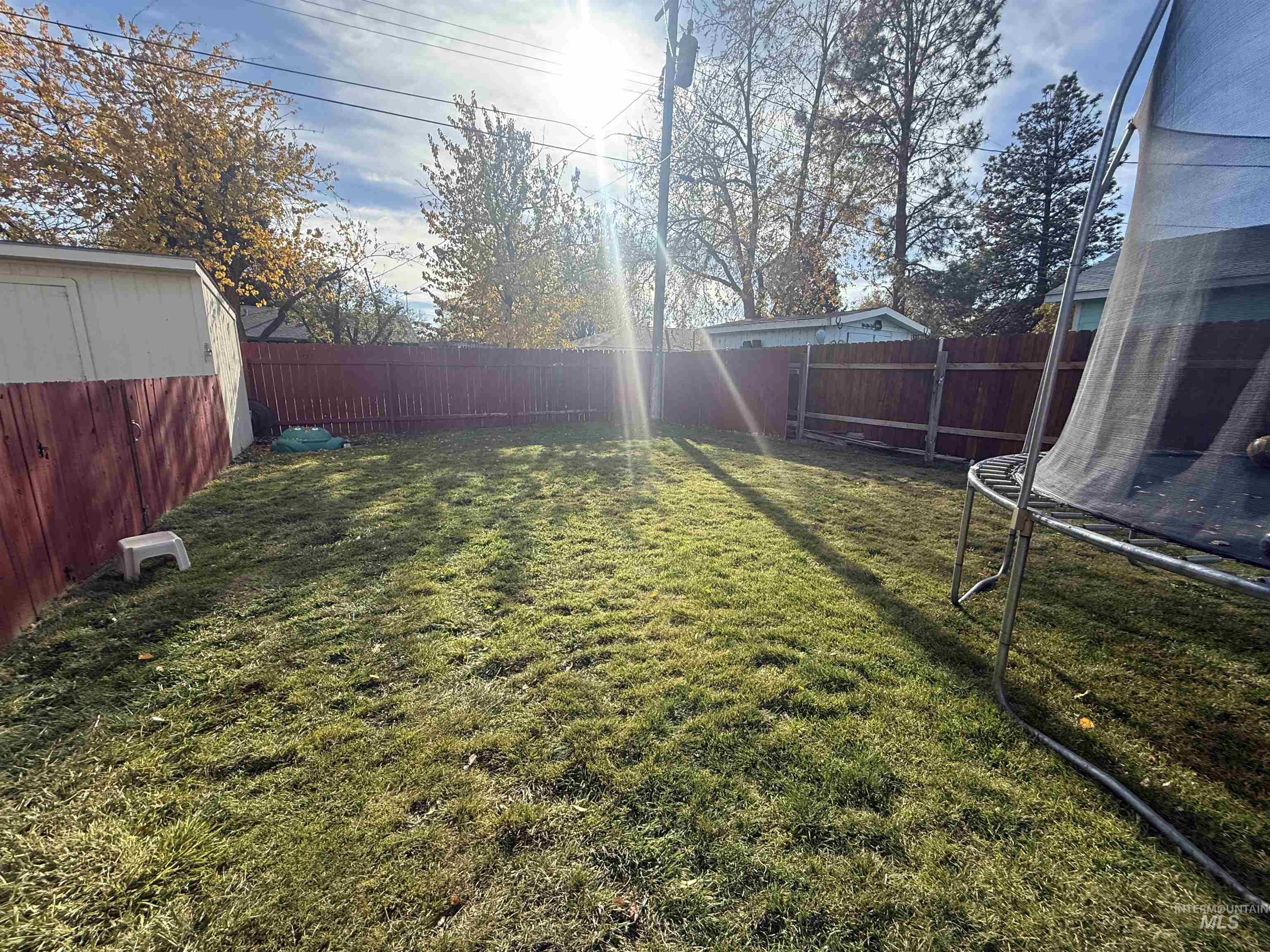 Fenced backyard with a trampoline