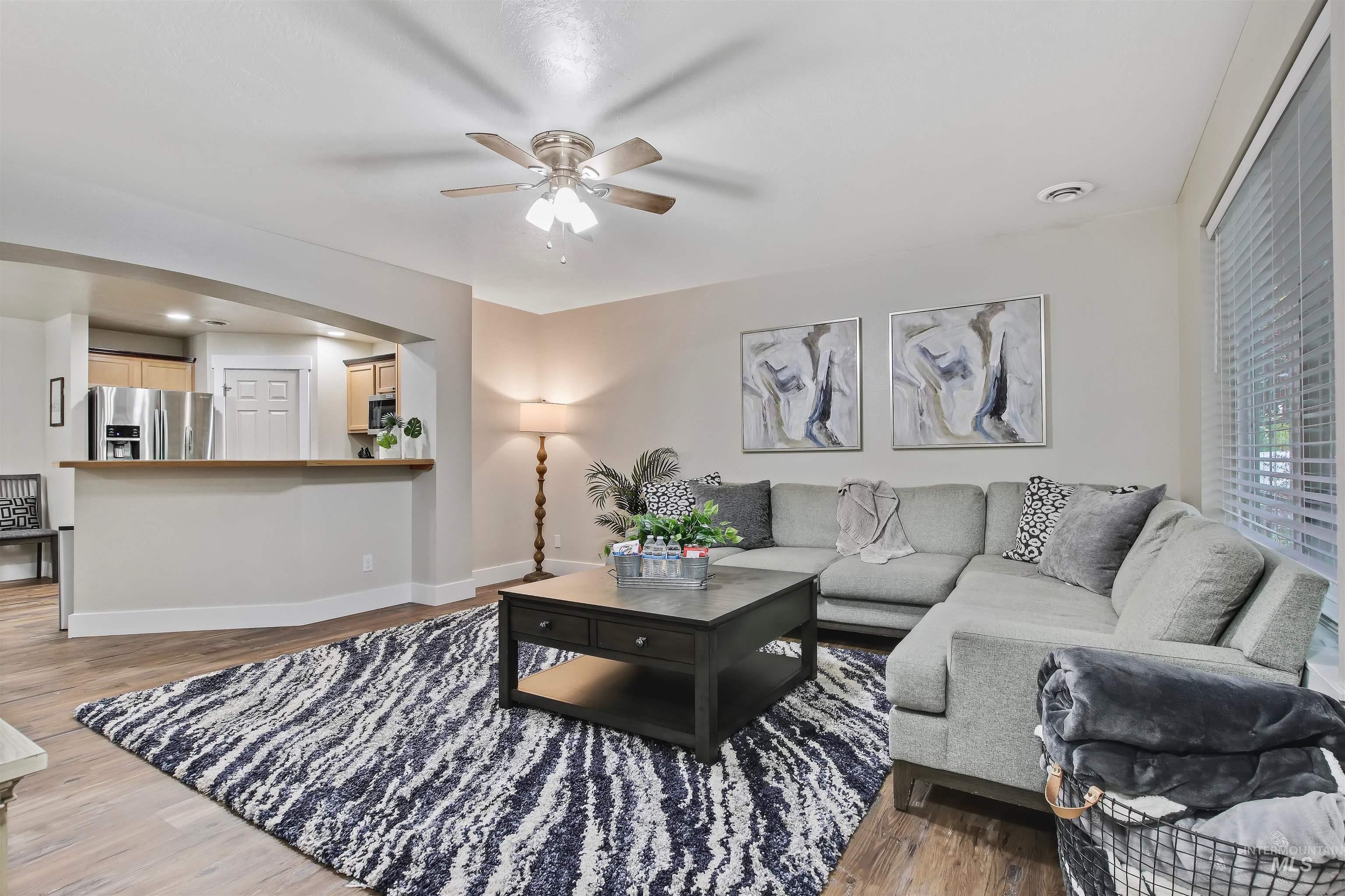 Living room with a ceiling fan and light wood finished floors