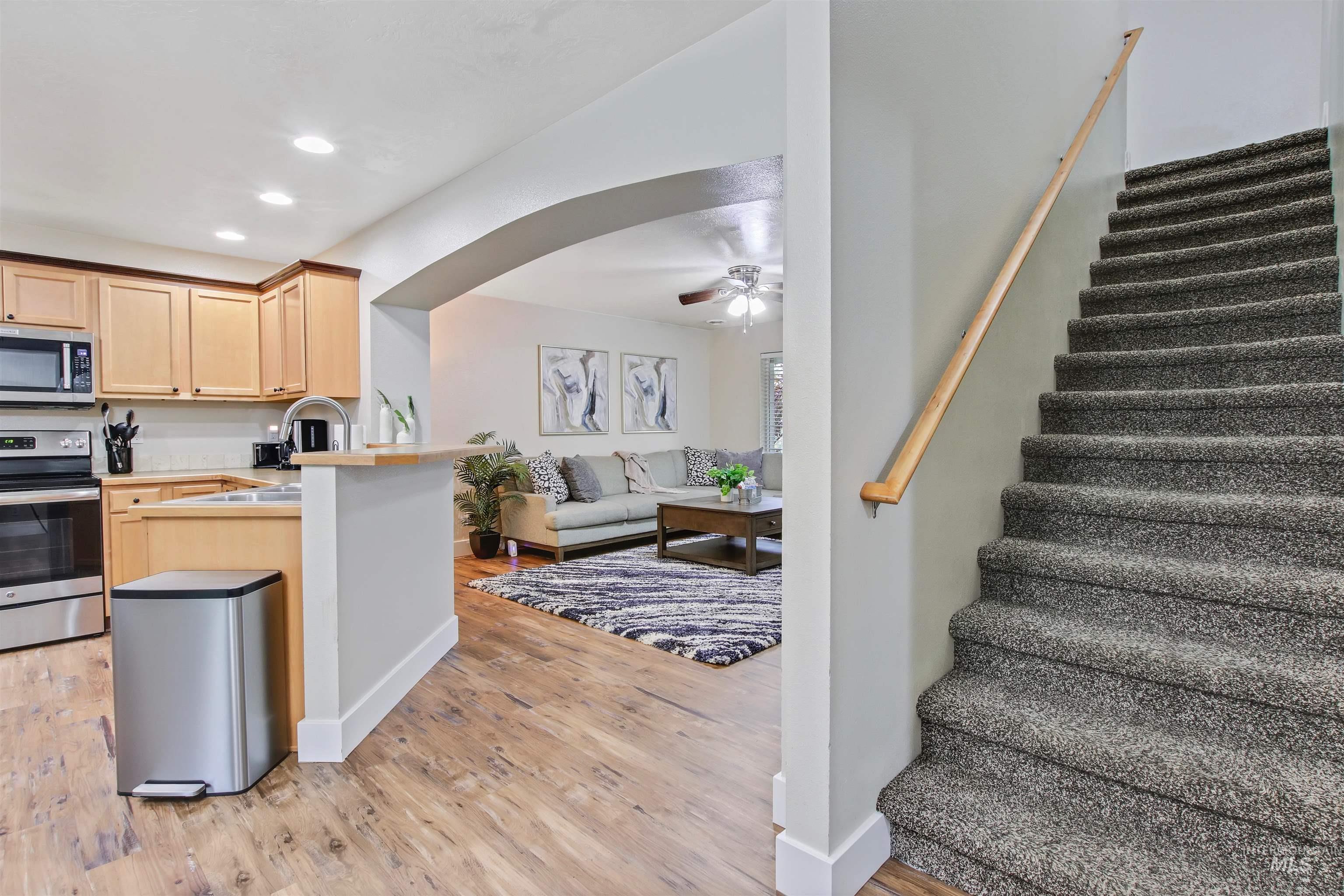 Kitchen with appliances with stainless steel finishes, light brown cabinetry, recessed lighting, open floor plan, and light wood-style floors