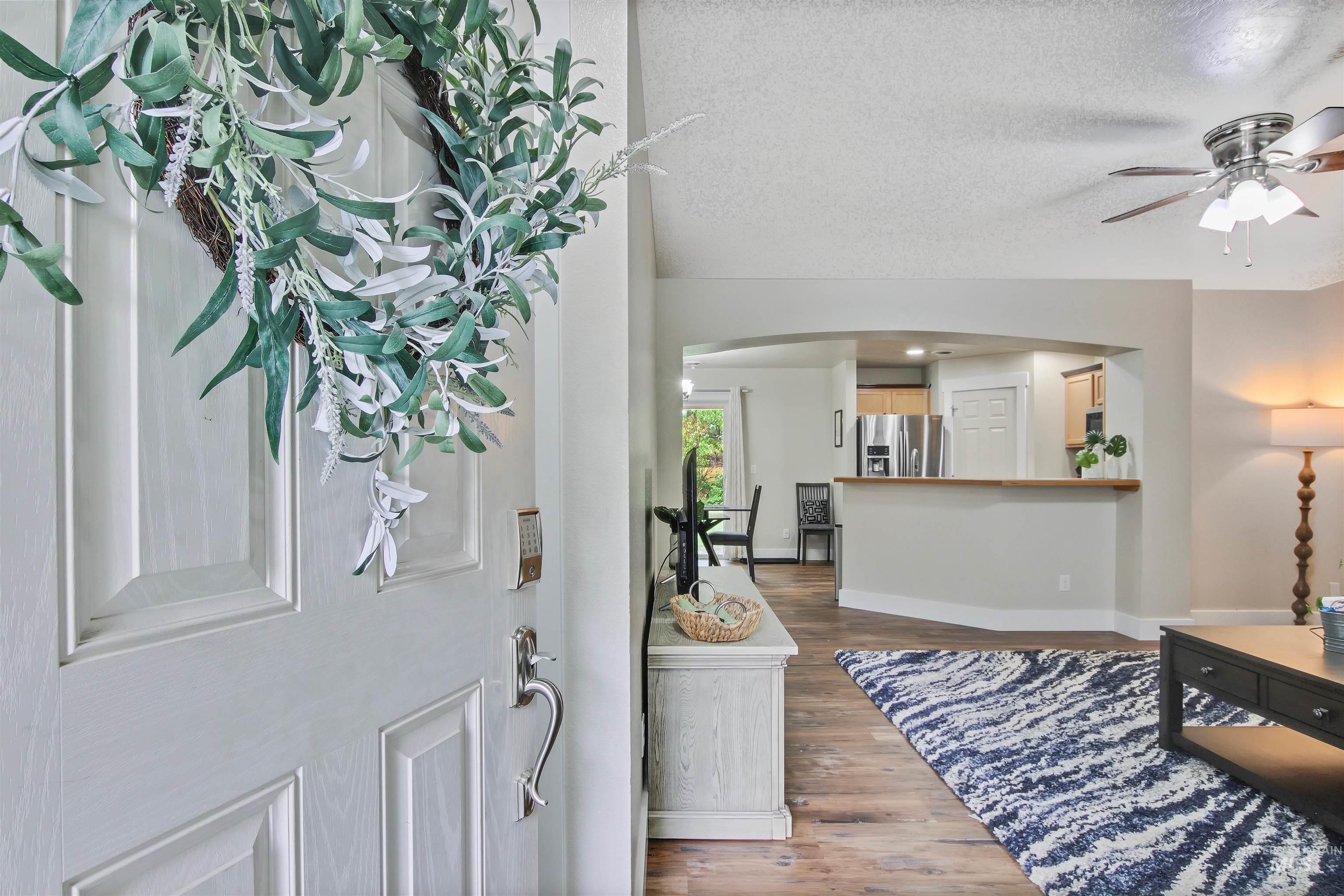 Foyer entrance with dark wood finished floors, a textured ceiling, arched walkways, and a ceiling fan