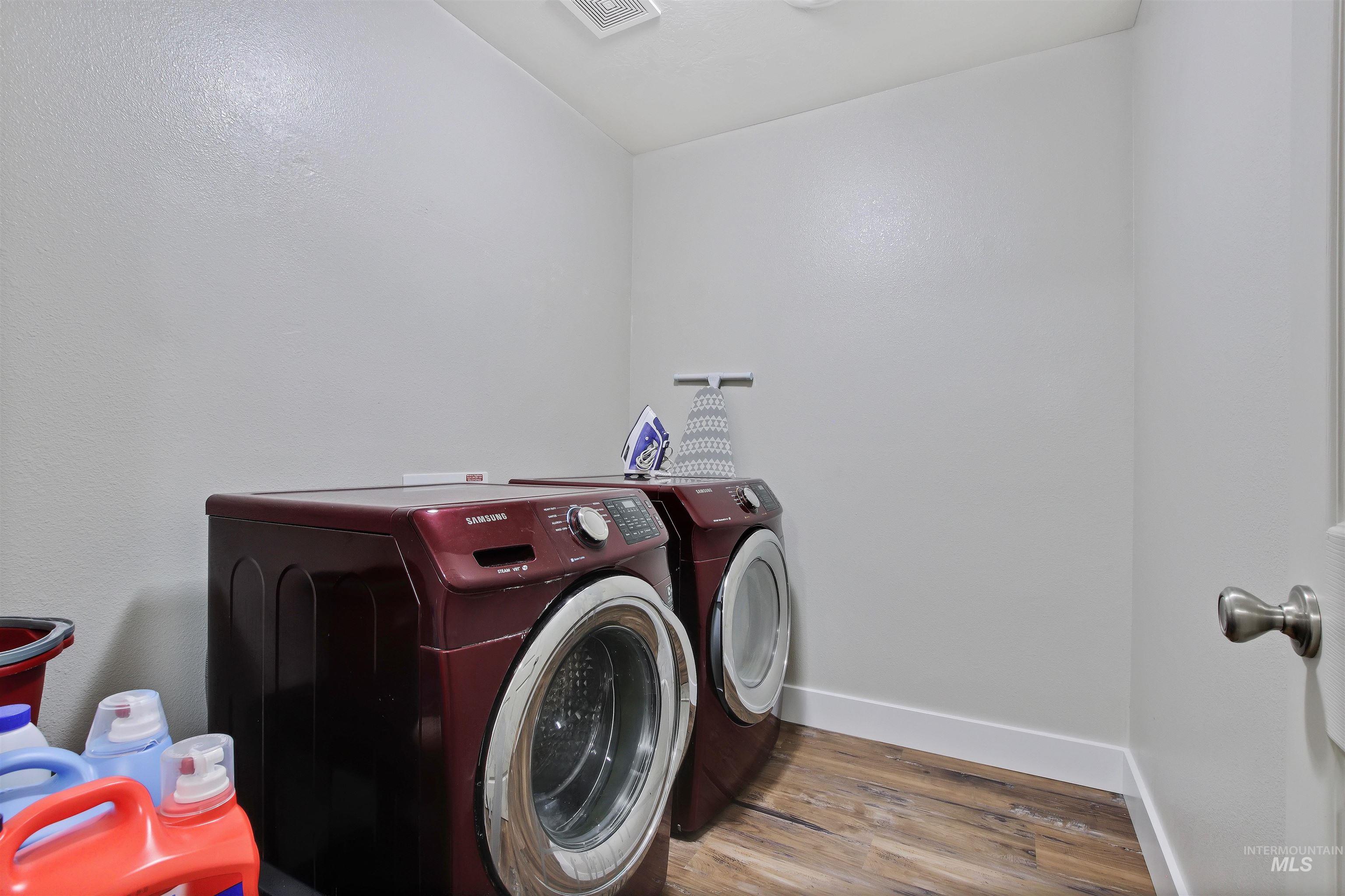 Laundry room featuring wood finished floors and separate washer and dryer