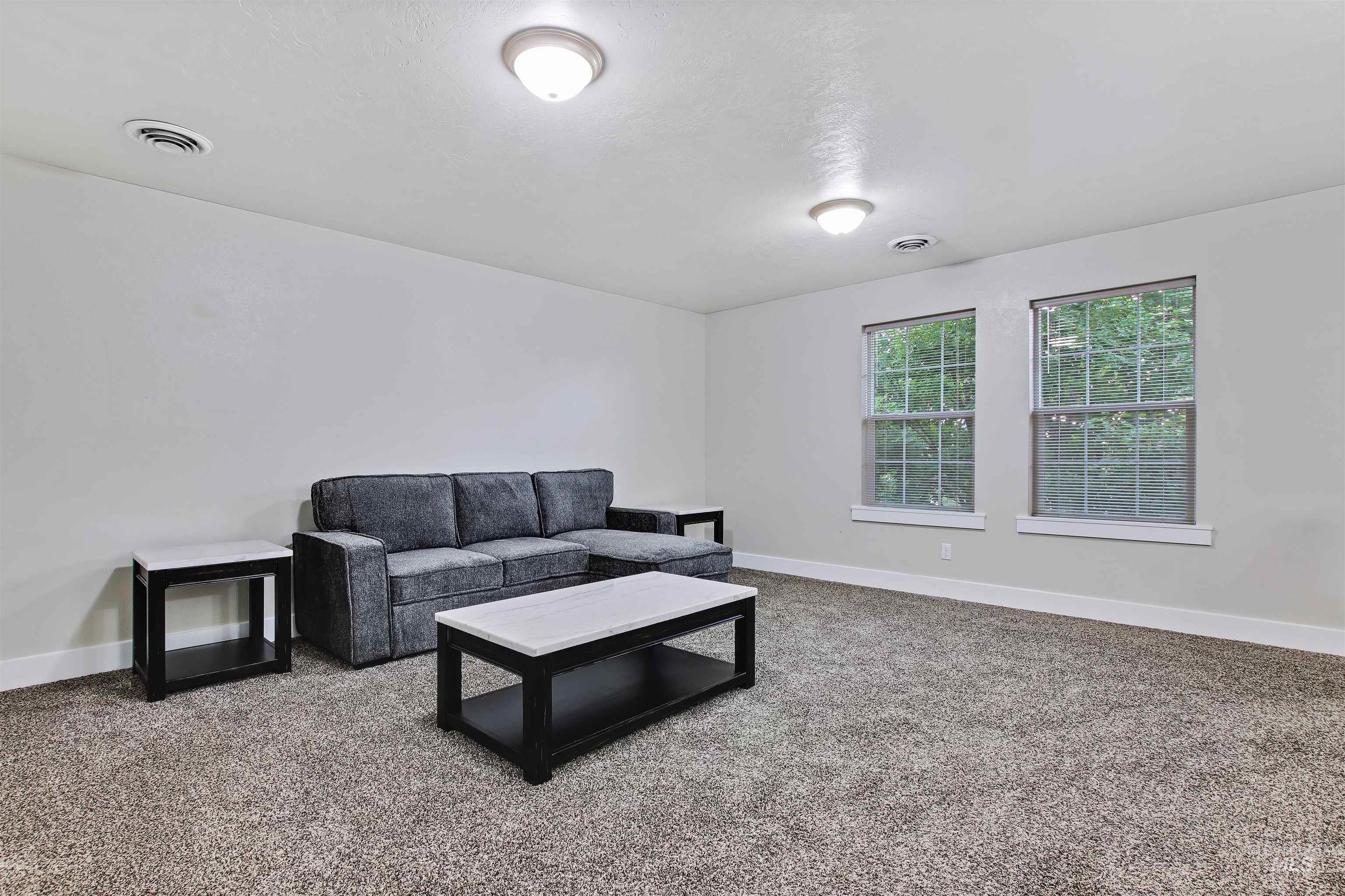 Living area featuring carpet floors and baseboards