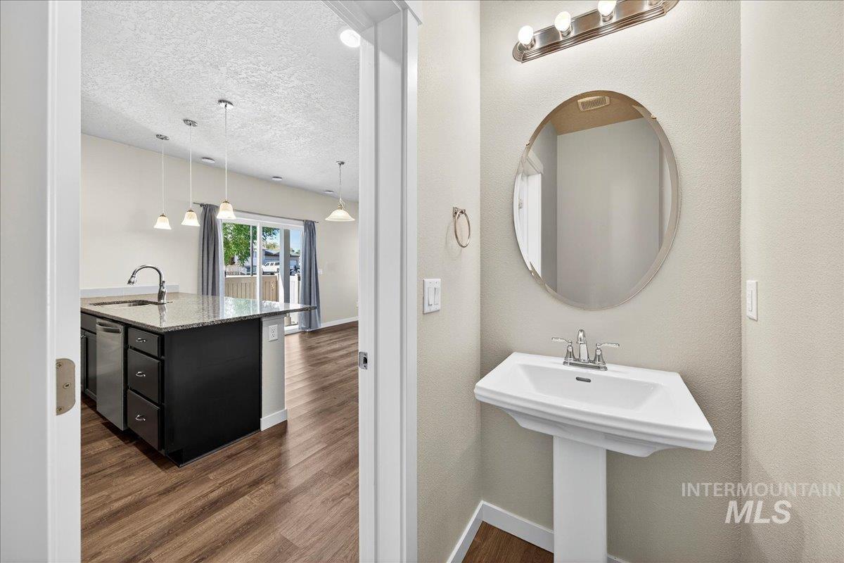 Bathroom with dark wood-style flooring and a textured ceiling