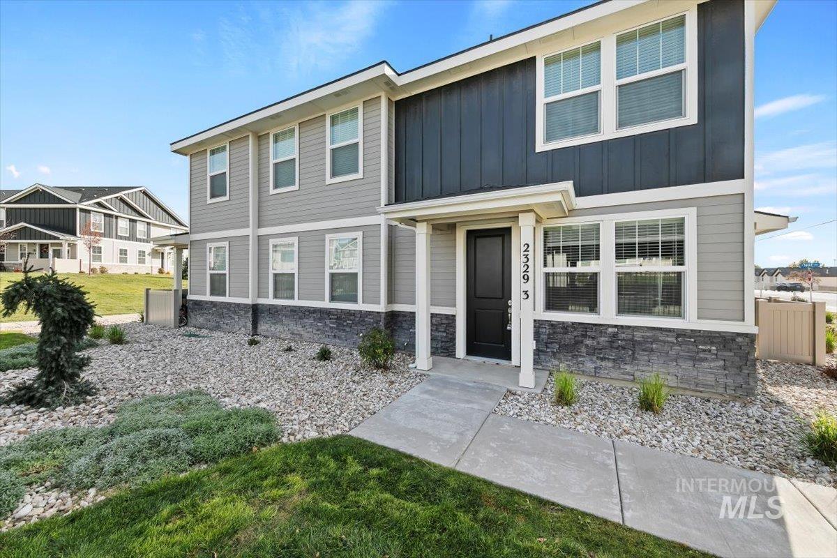 View of front of house featuring stone siding and board and batten siding