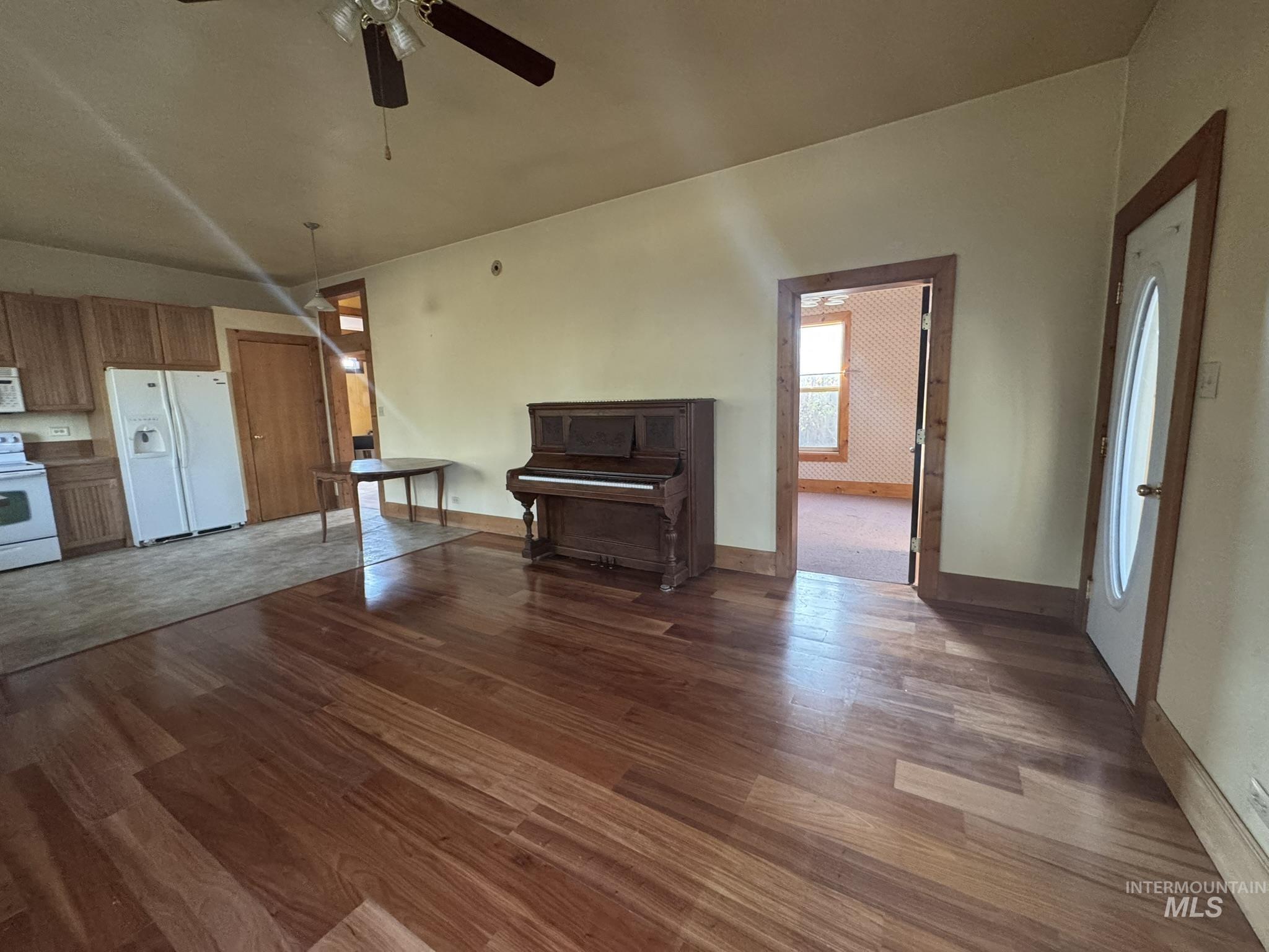 Unfurnished living room with dark wood-type flooring and ceiling fan