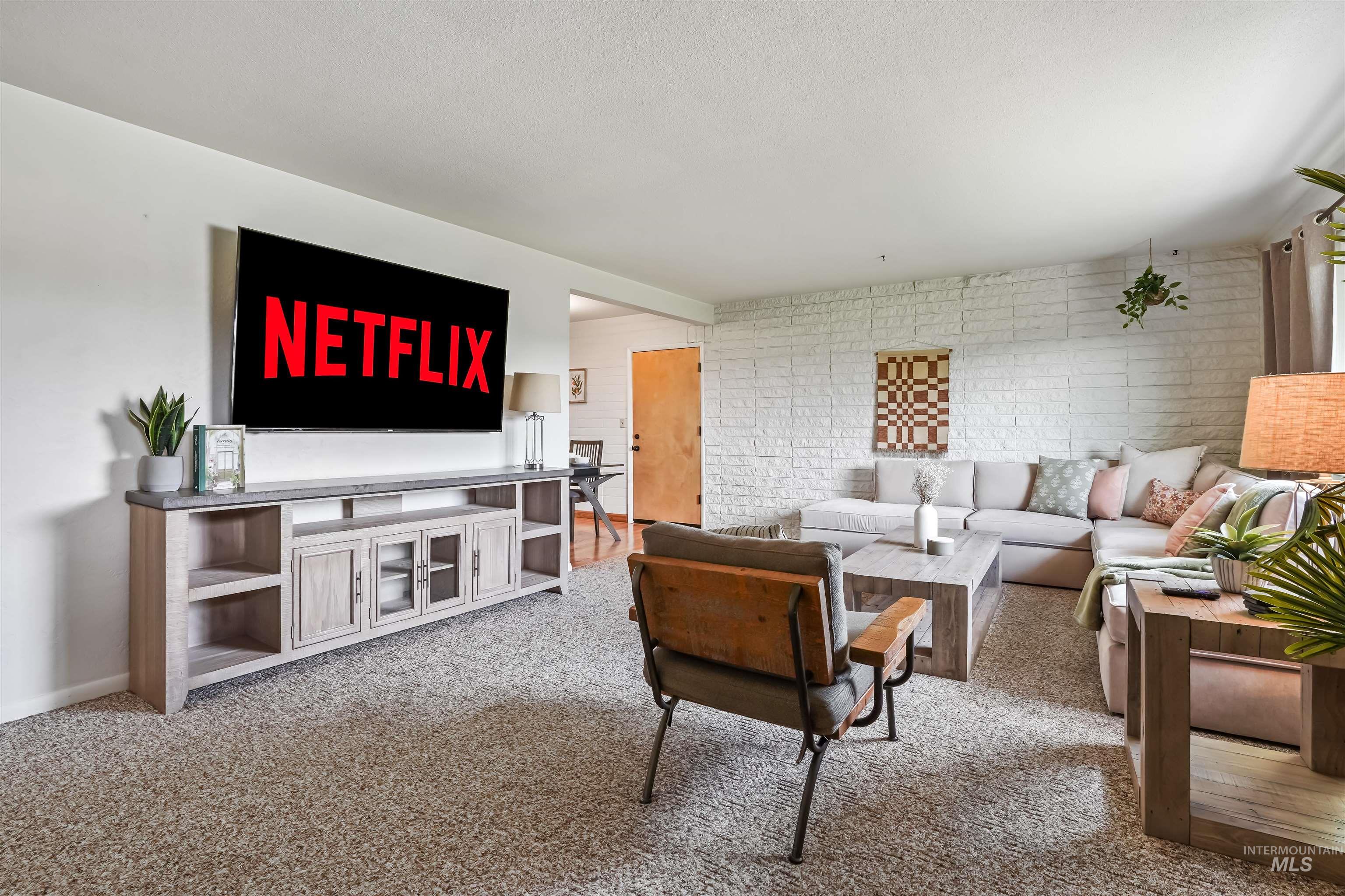 Living area featuring light carpet and baseboards