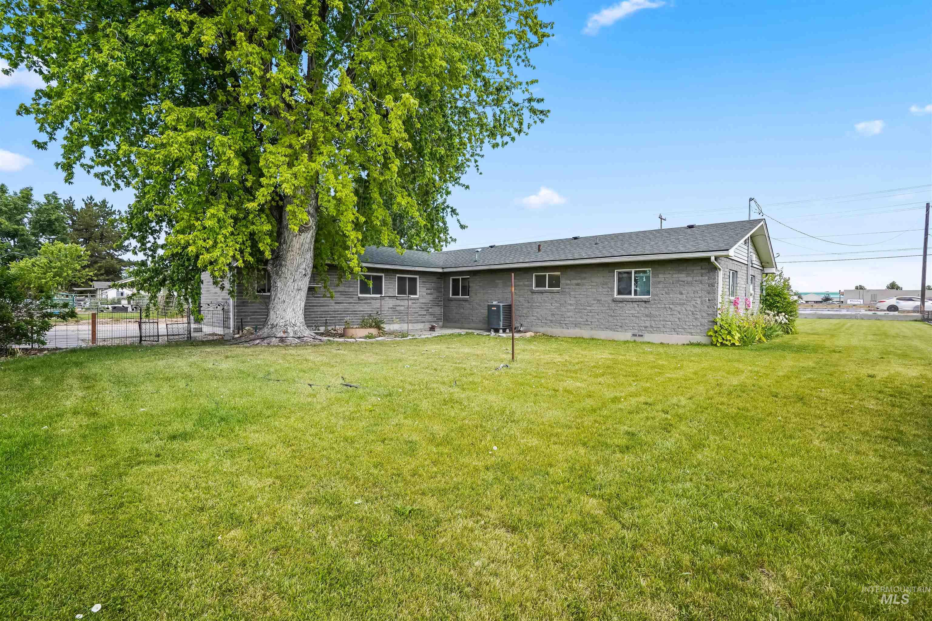 Back of property featuring brick siding and roof with shingles