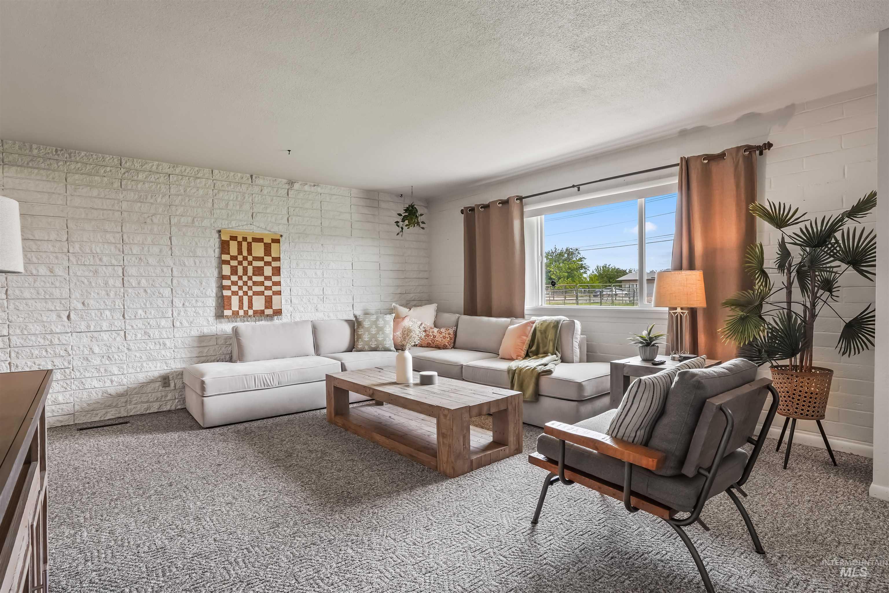 Living area with carpet flooring and a textured ceiling