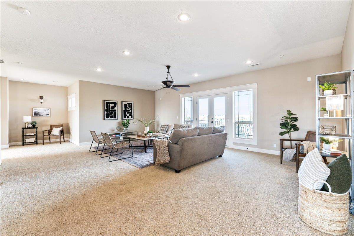 Living room featuring light colored carpet, ceiling fan, recessed lighting, and french doors