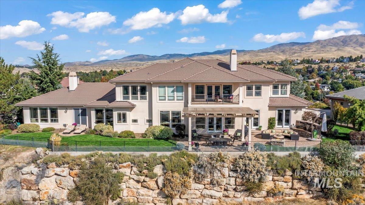 Back of property with a chimney, a patio area, a fenced backyard, and a mountain view