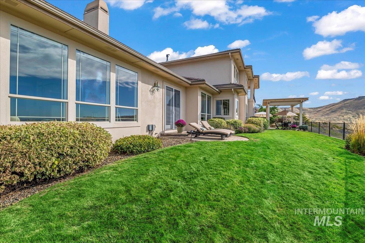 Rear view of property featuring stucco siding, a patio area, a chimney, and a mountain view