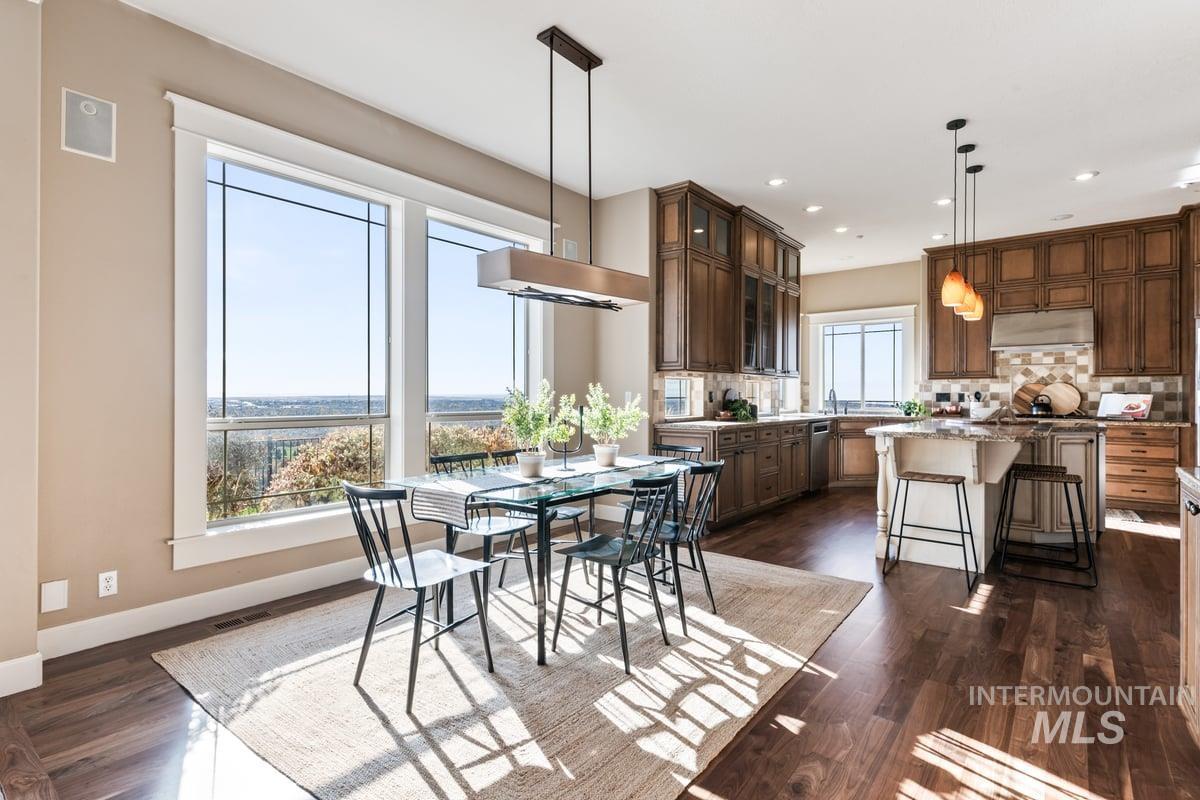 Dining room with dark wood-style flooring and recessed lighting