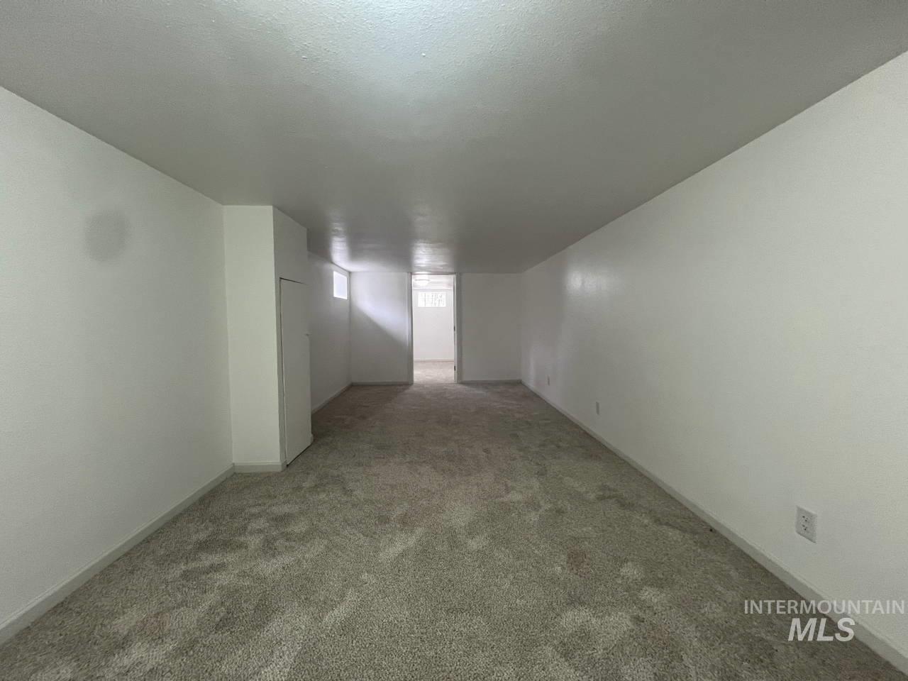 Carpeted spare room with baseboards and a textured ceiling