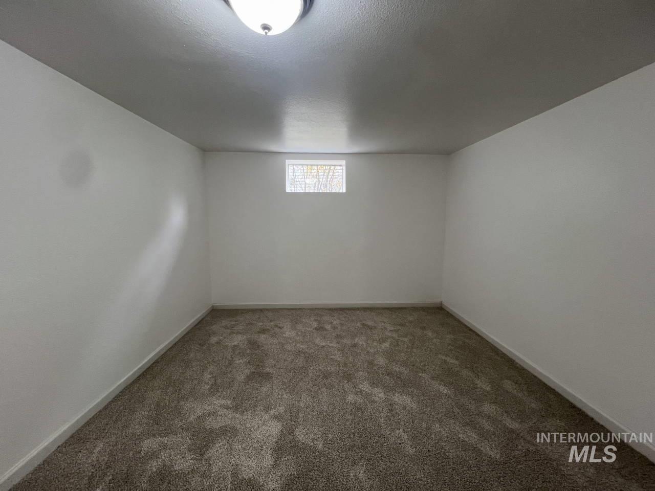 Below grade area with carpet floors and a textured ceiling