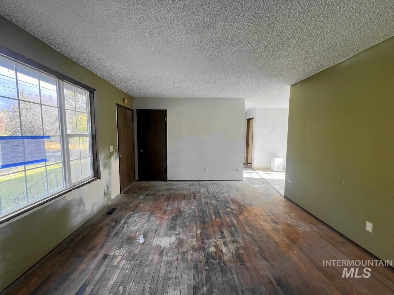 Unfurnished room featuring a textured ceiling and hardwood / wood-style floors
