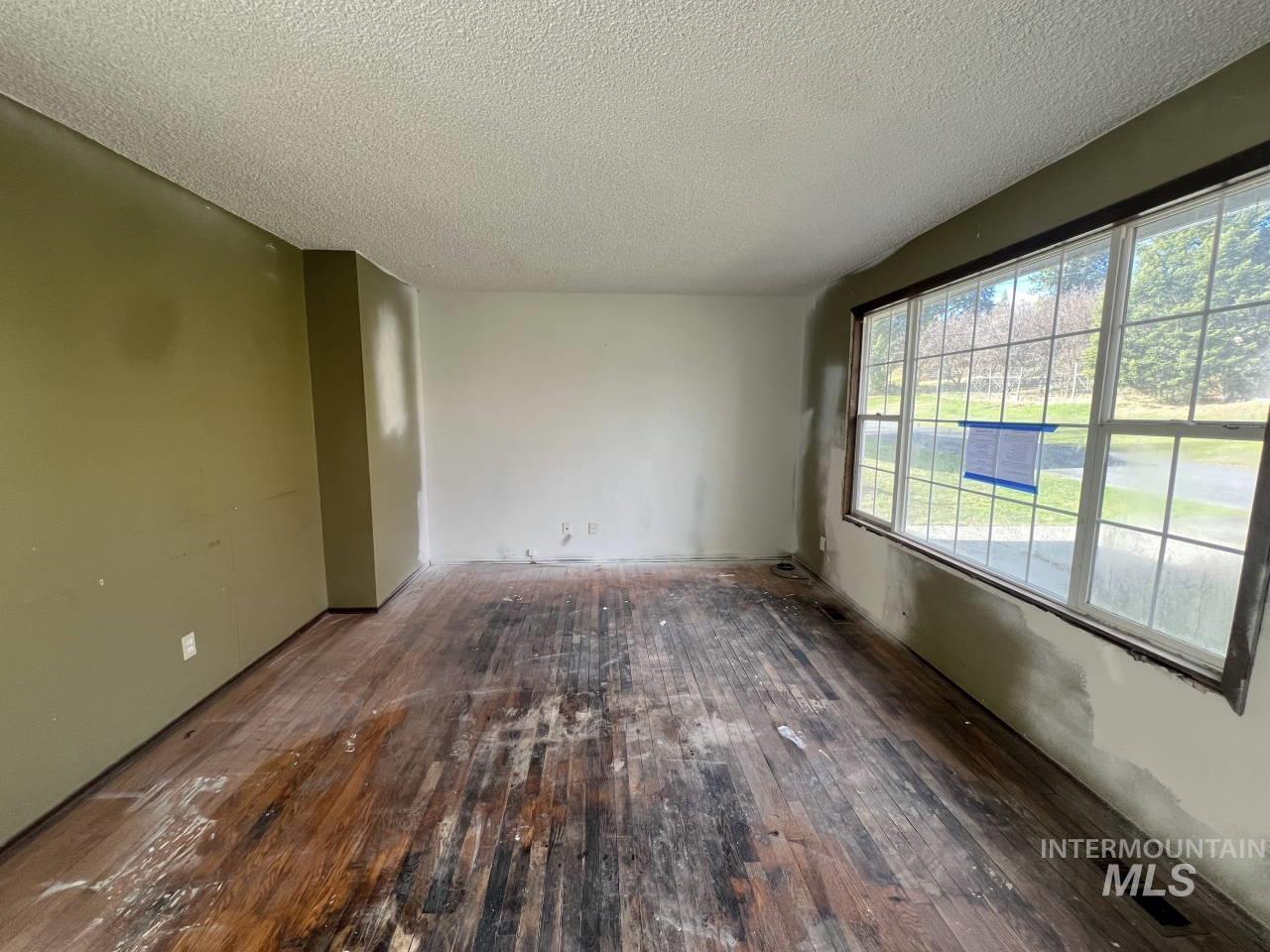 Spare room with dark wood-style floors and a textured ceiling