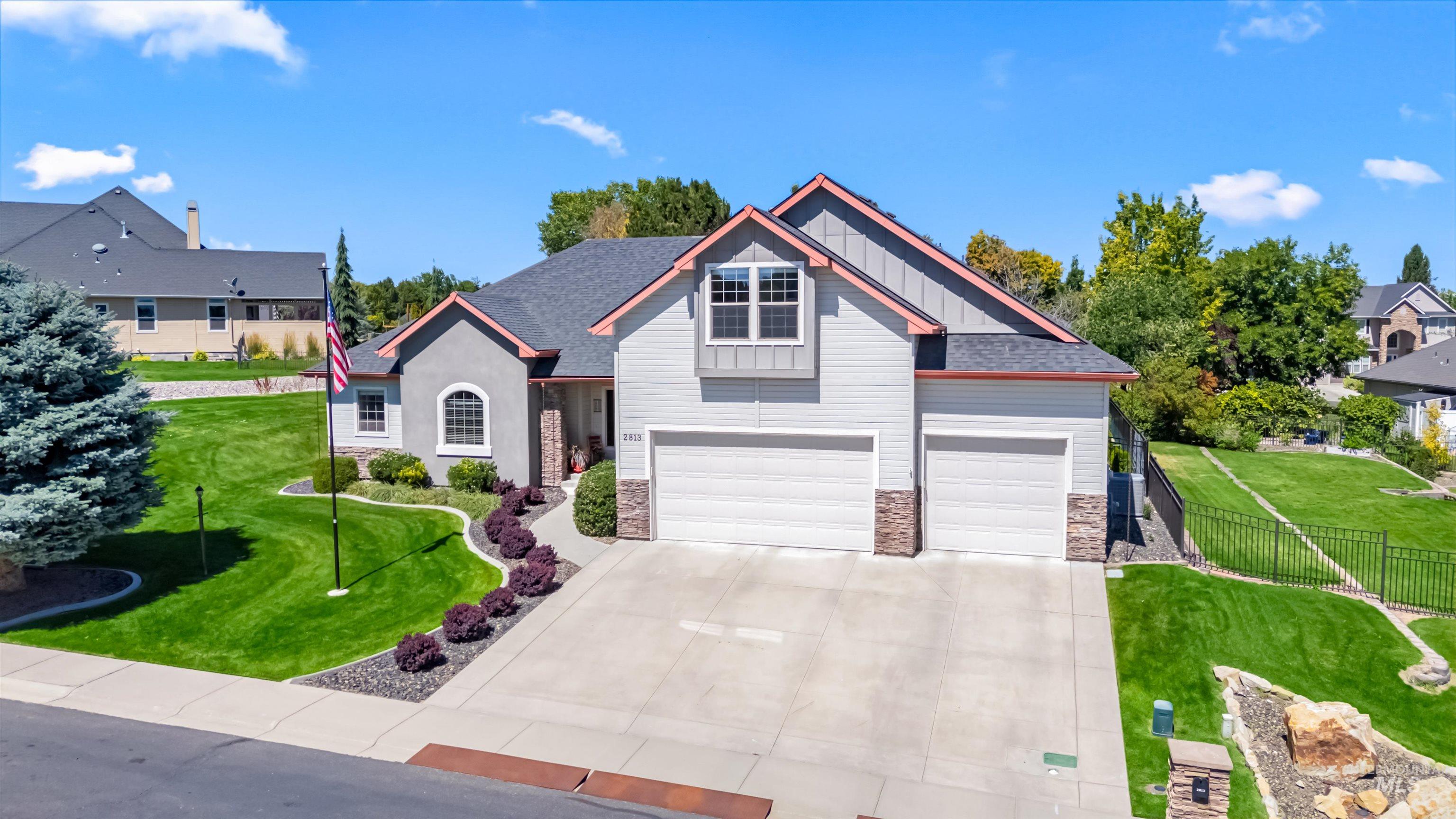 Craftsman-style home with stone siding, board and batten siding, concrete driveway, a garage, and a shingled roof