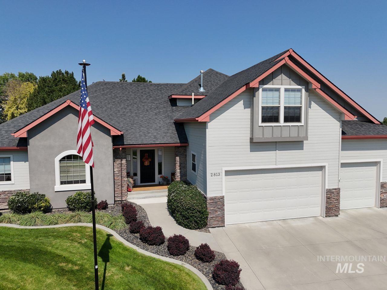 Craftsman inspired home featuring stone siding, concrete driveway, and a shingled roof