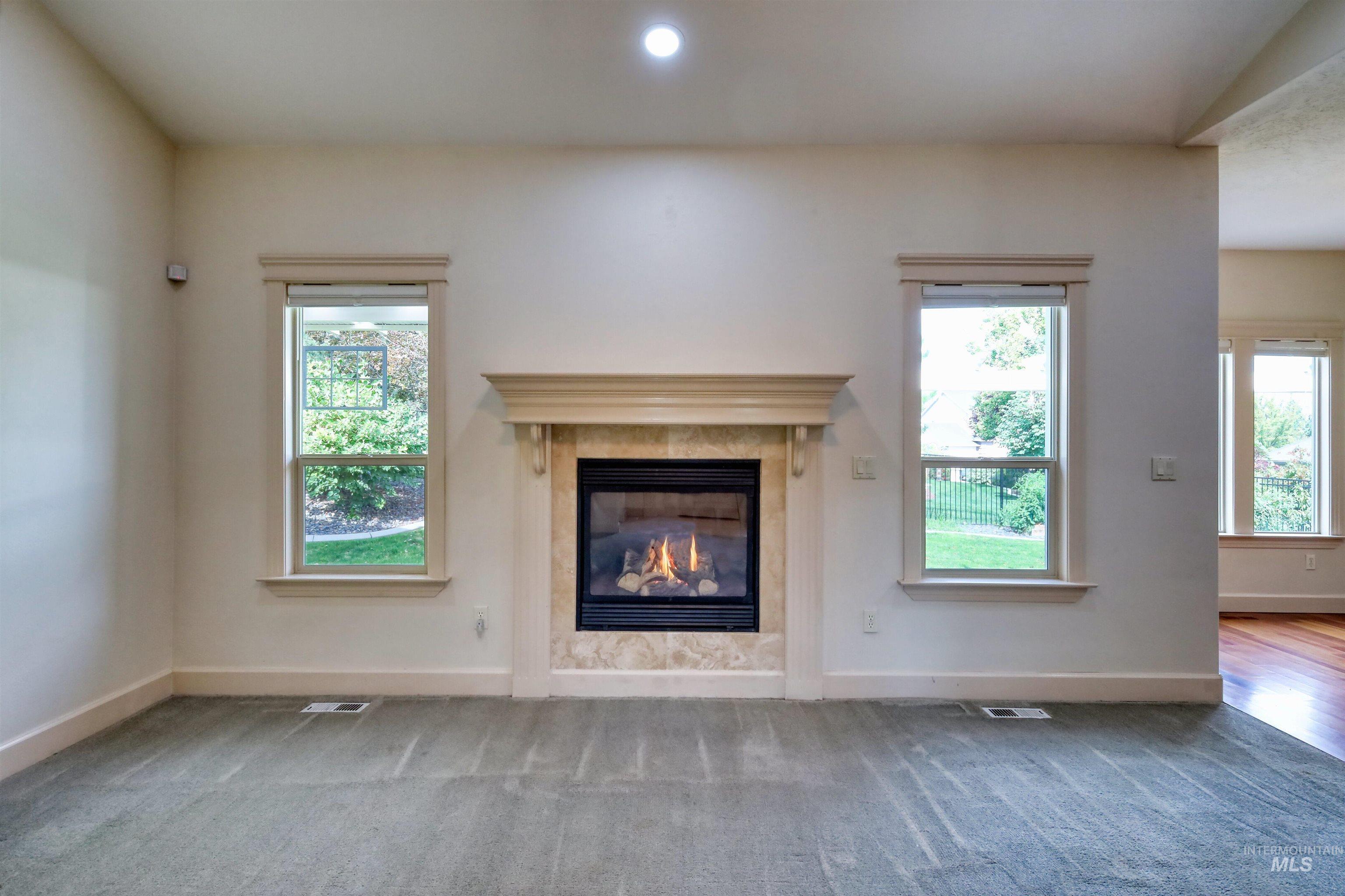 Unfurnished living room with a fireplace, carpet, and recessed lighting