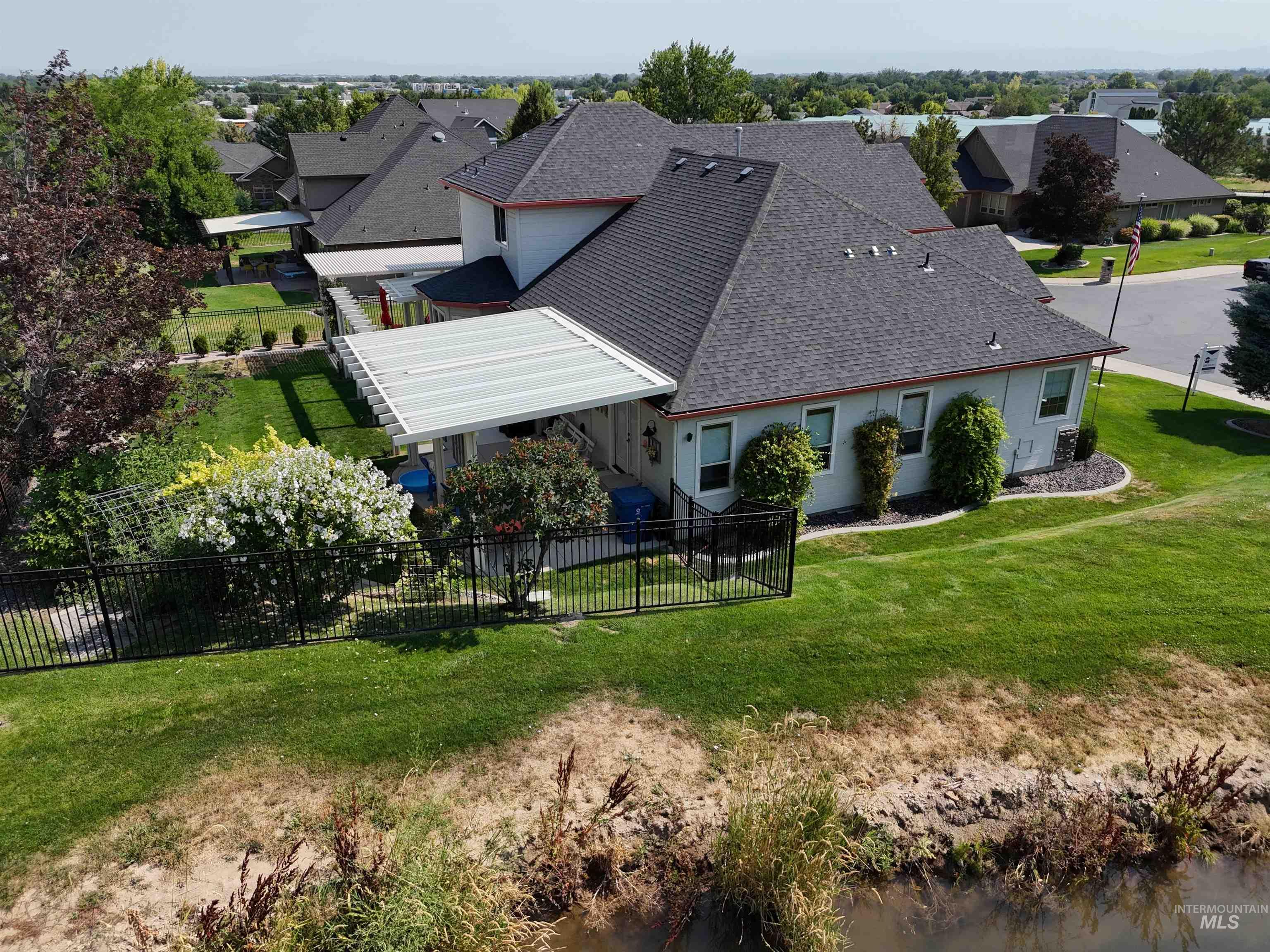 Back of property featuring roof with shingles, a fenced backyard, and a residential view