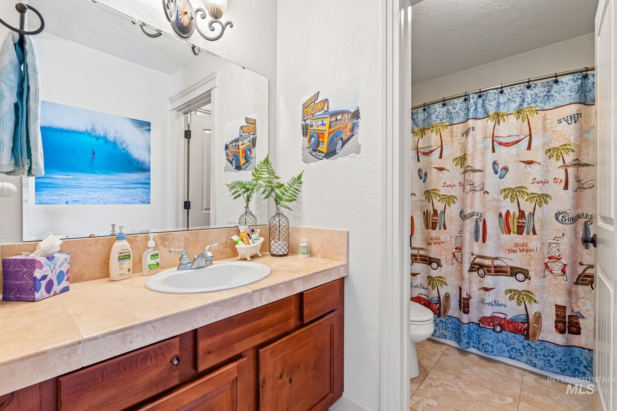 Bathroom featuring vanity, tile patterned flooring, and a shower with shower curtain
