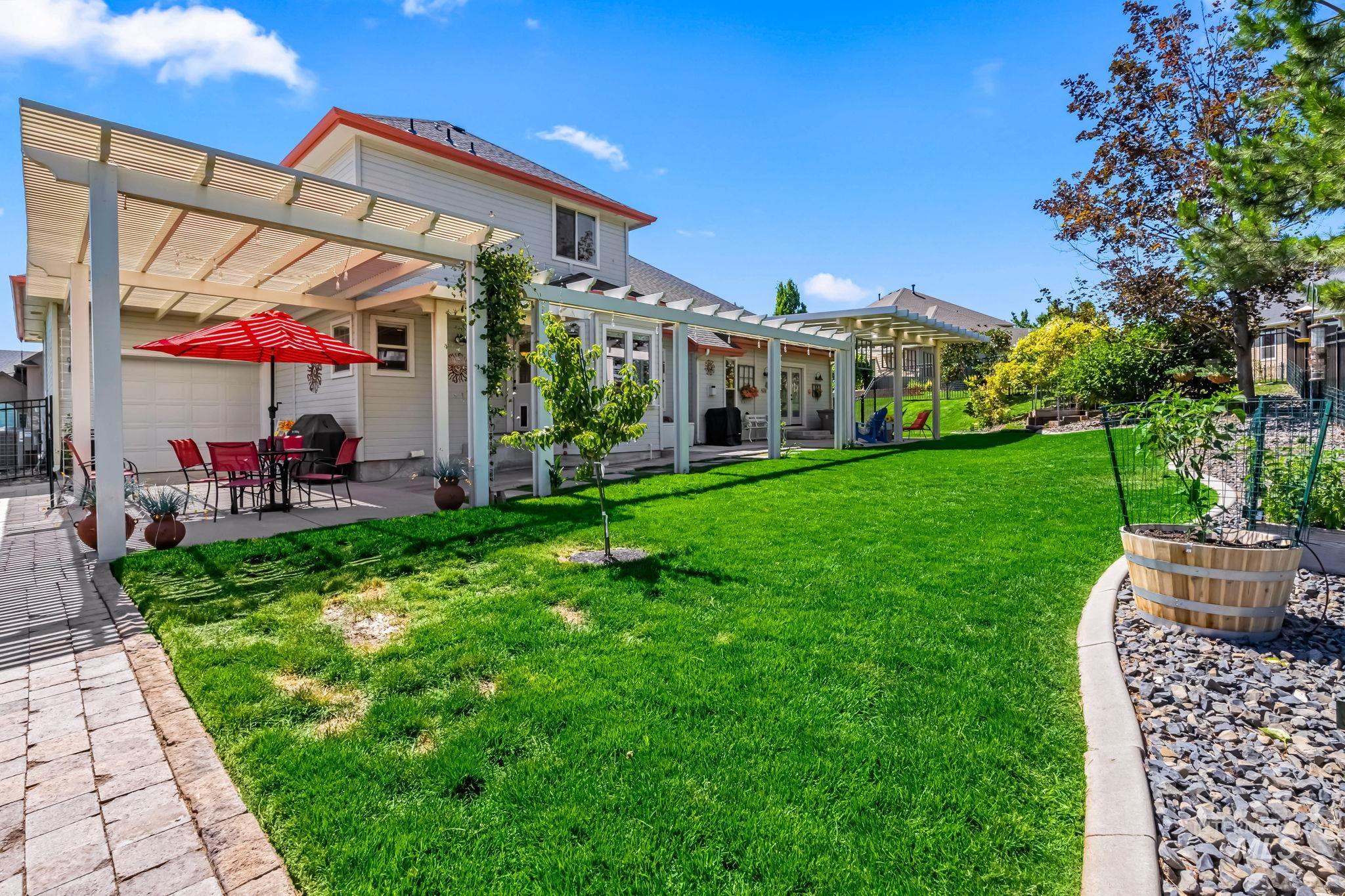 View of green lawn featuring a pergola and a patio