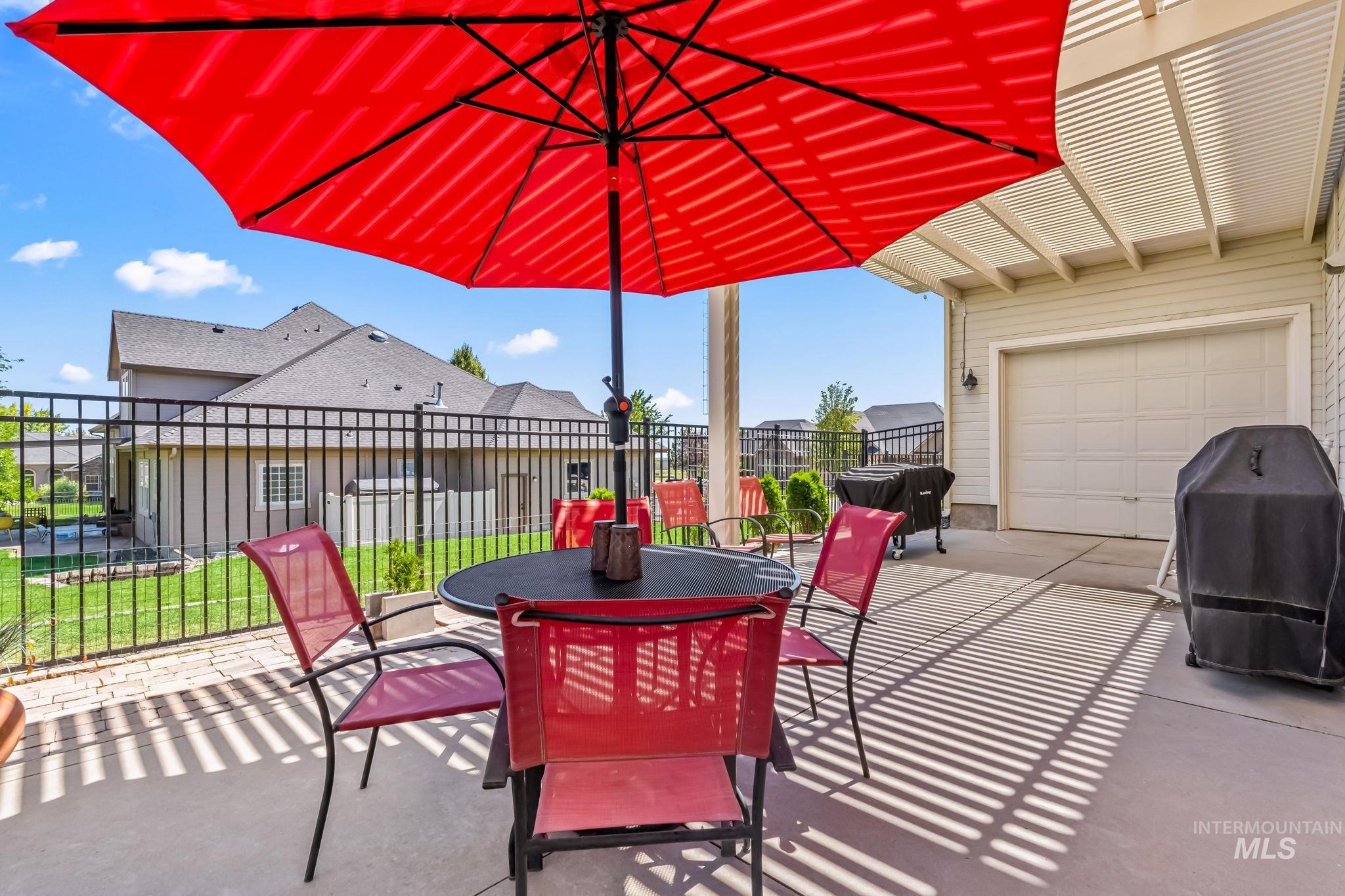 View of patio featuring a garage, grilling area, and outdoor dining area