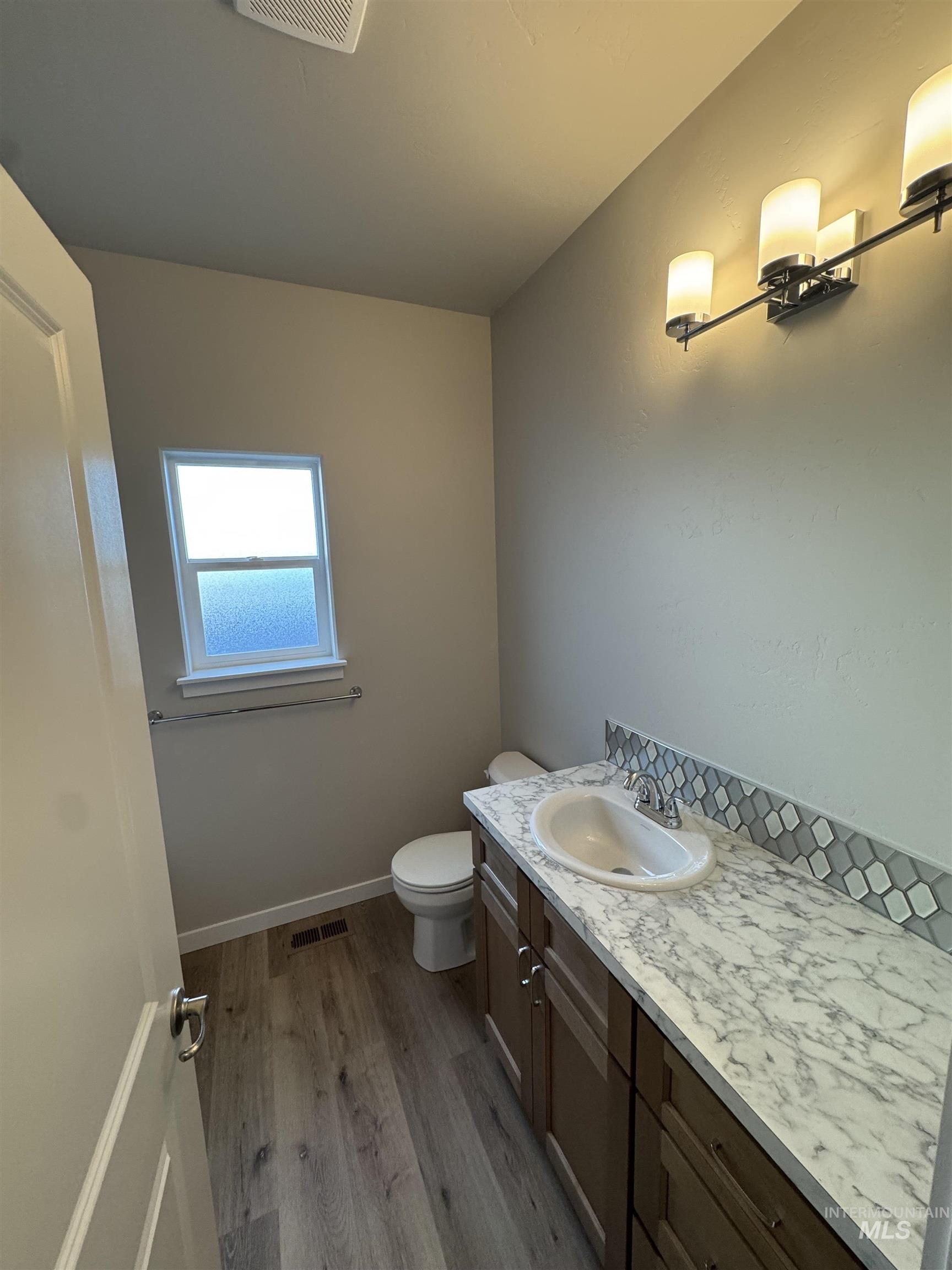 Half bathroom featuring dark wood-style flooring and vanity
