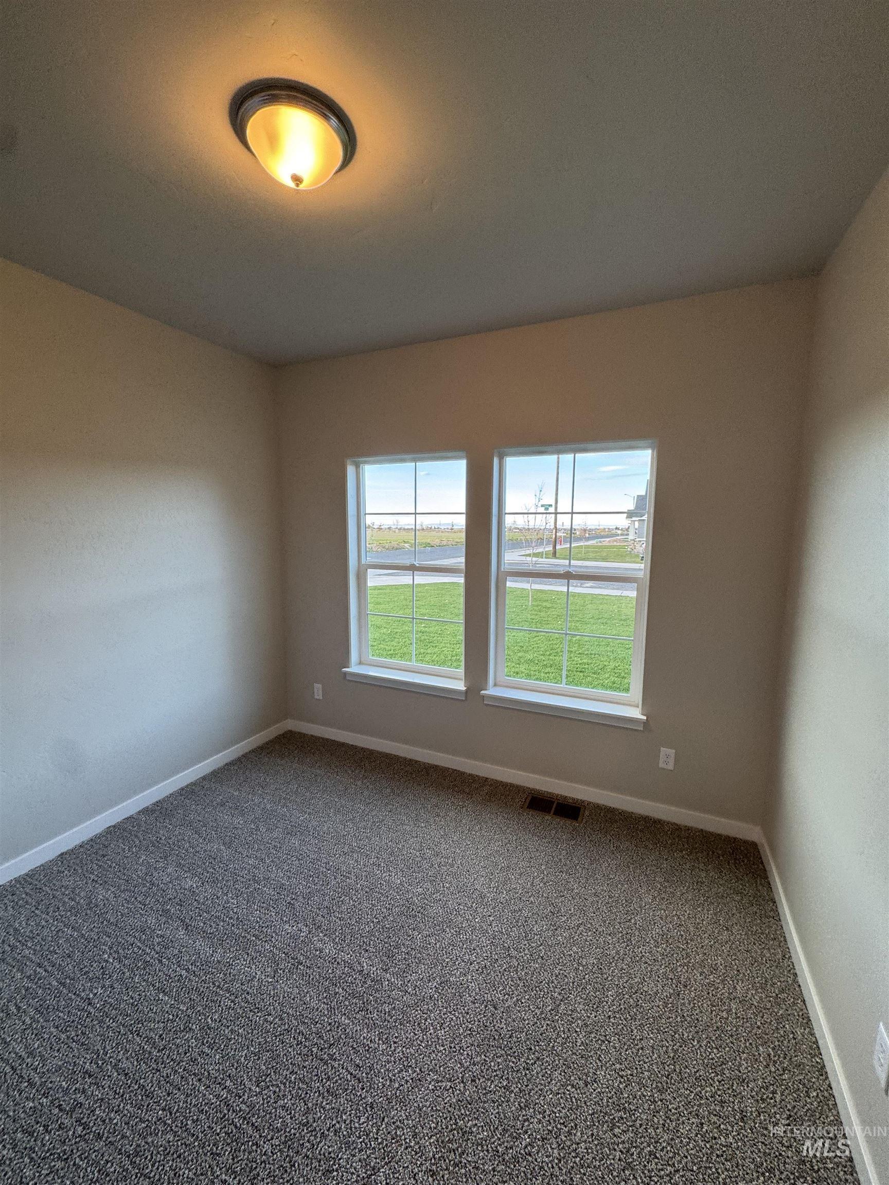 Unfurnished room featuring carpet and baseboards