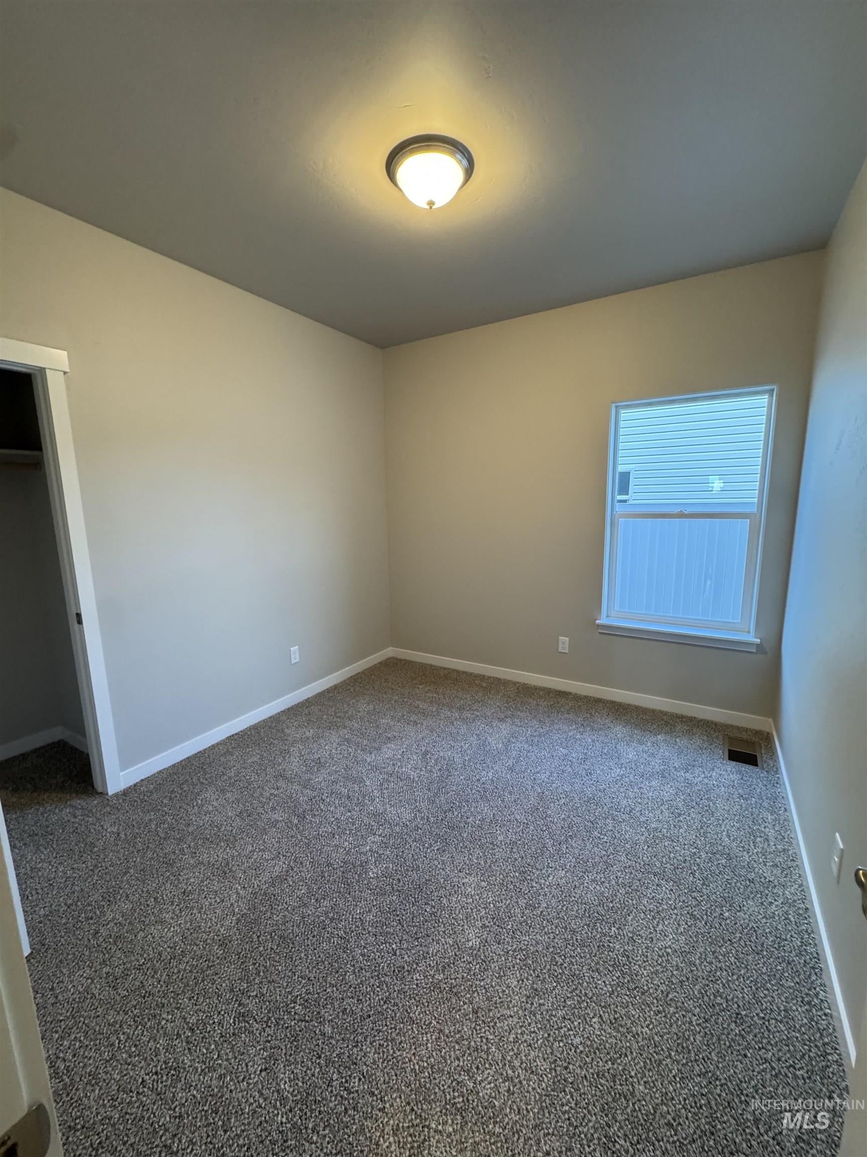 Unfurnished bedroom featuring carpet flooring and a closet