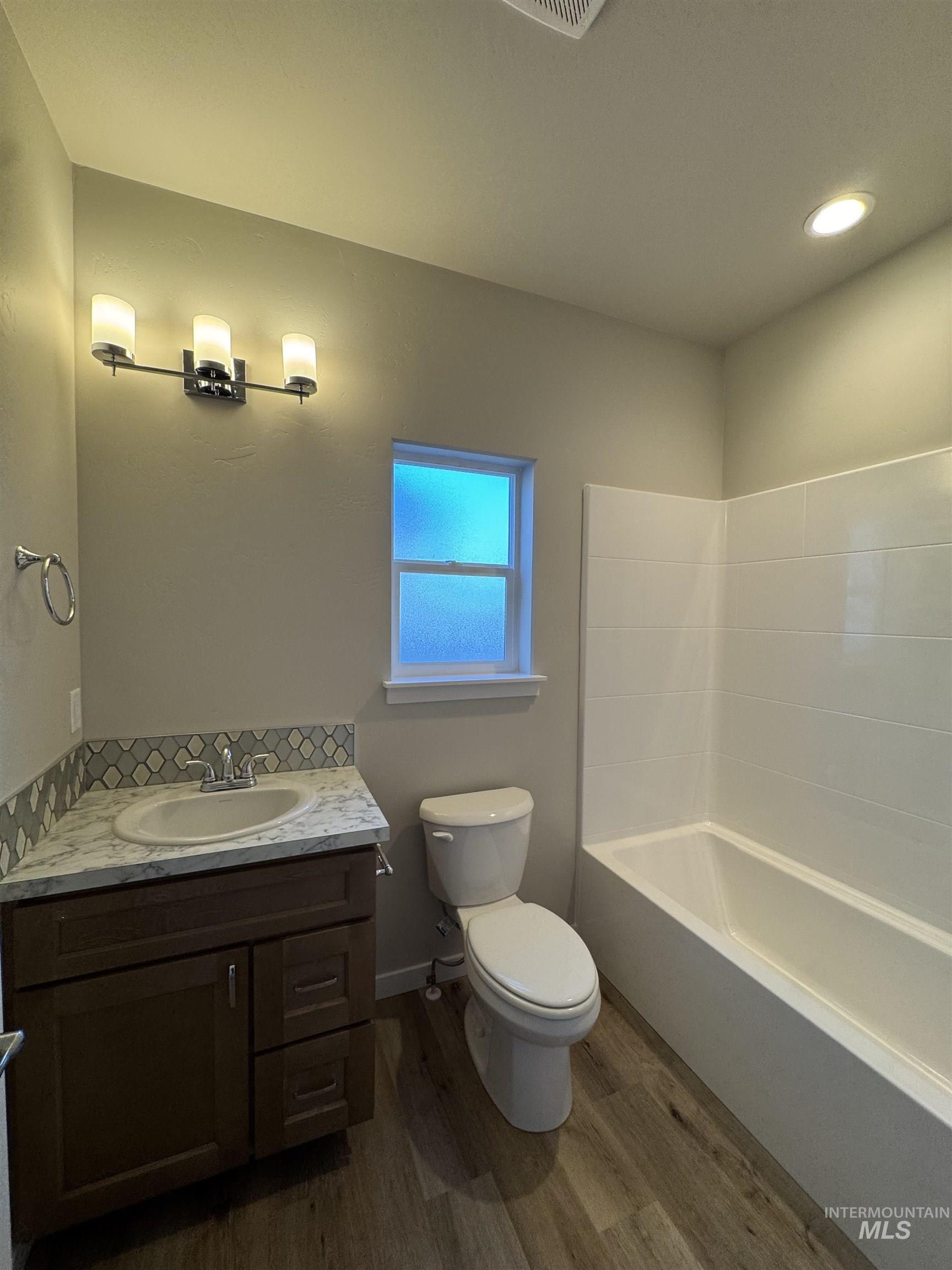 Bathroom featuring dark wood finished floors, vanity, and recessed lighting