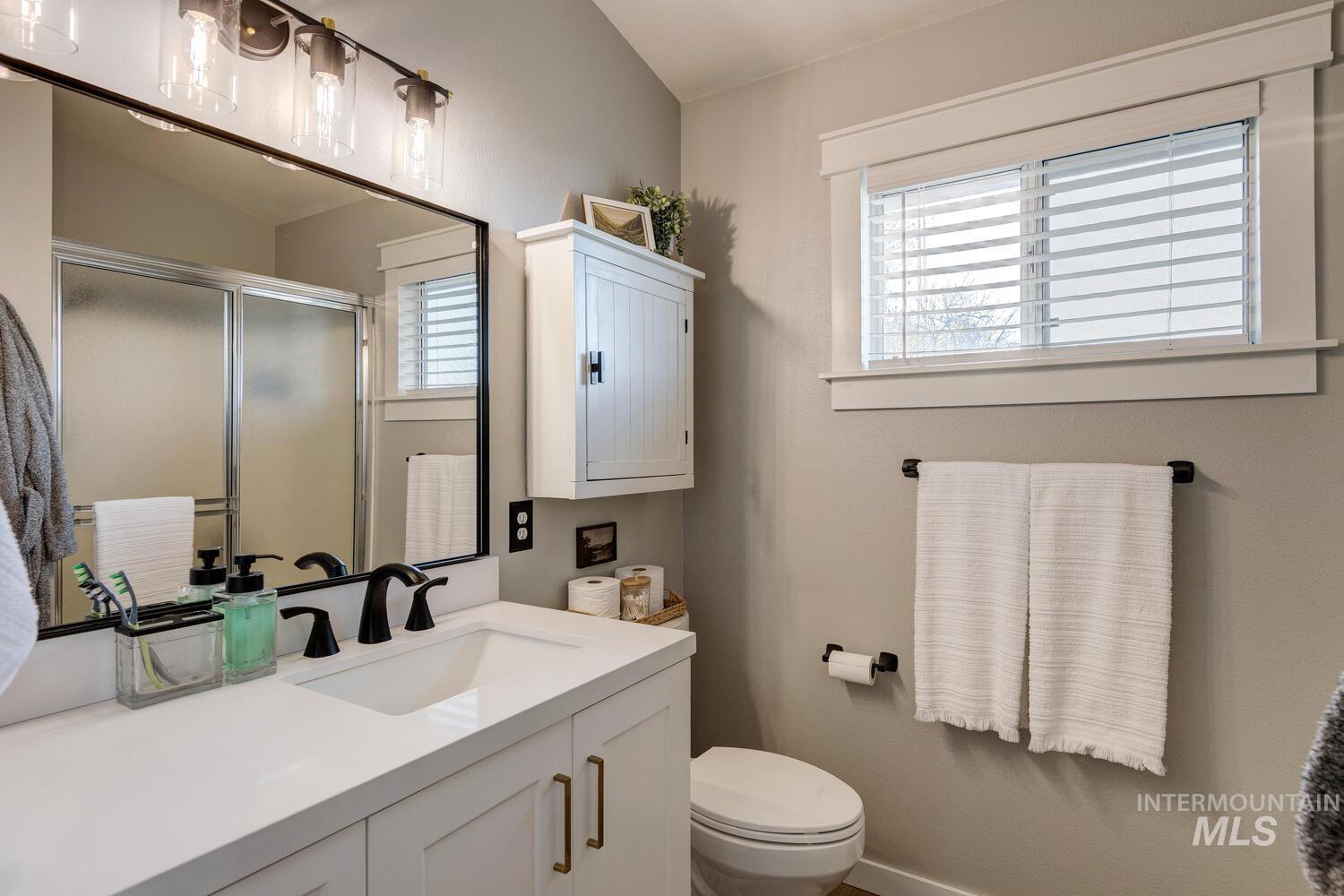Full bath featuring a stall shower and vanity